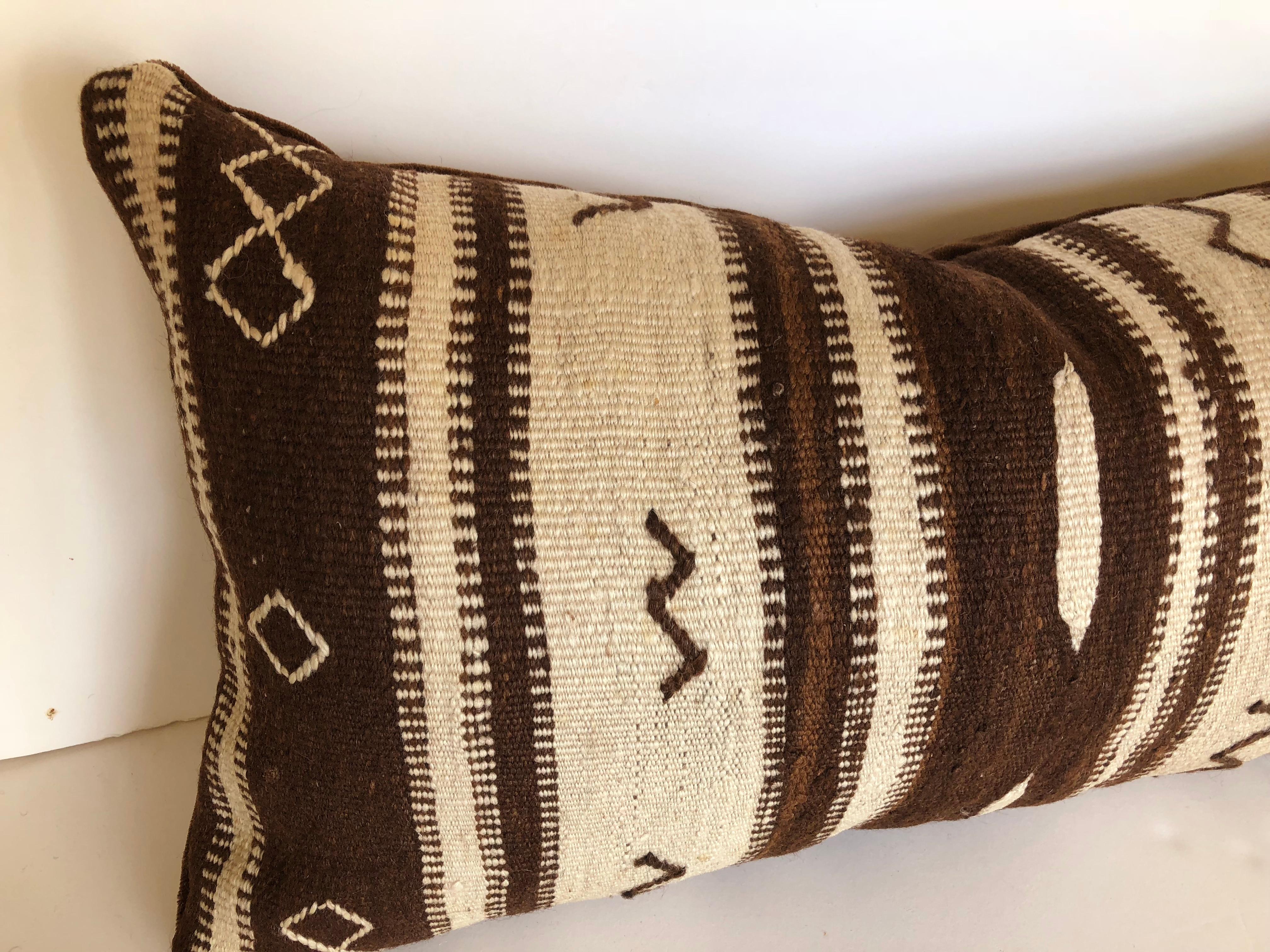 Custom pillow cut from a vintage hand loomed wool Moroccan Ourika rug, upper Atlas Mountains. The wool is soft and lustrous with tribal designs and natural color. Pillow is backed in dark brown velvet, filled with an insert of 50/50 down and