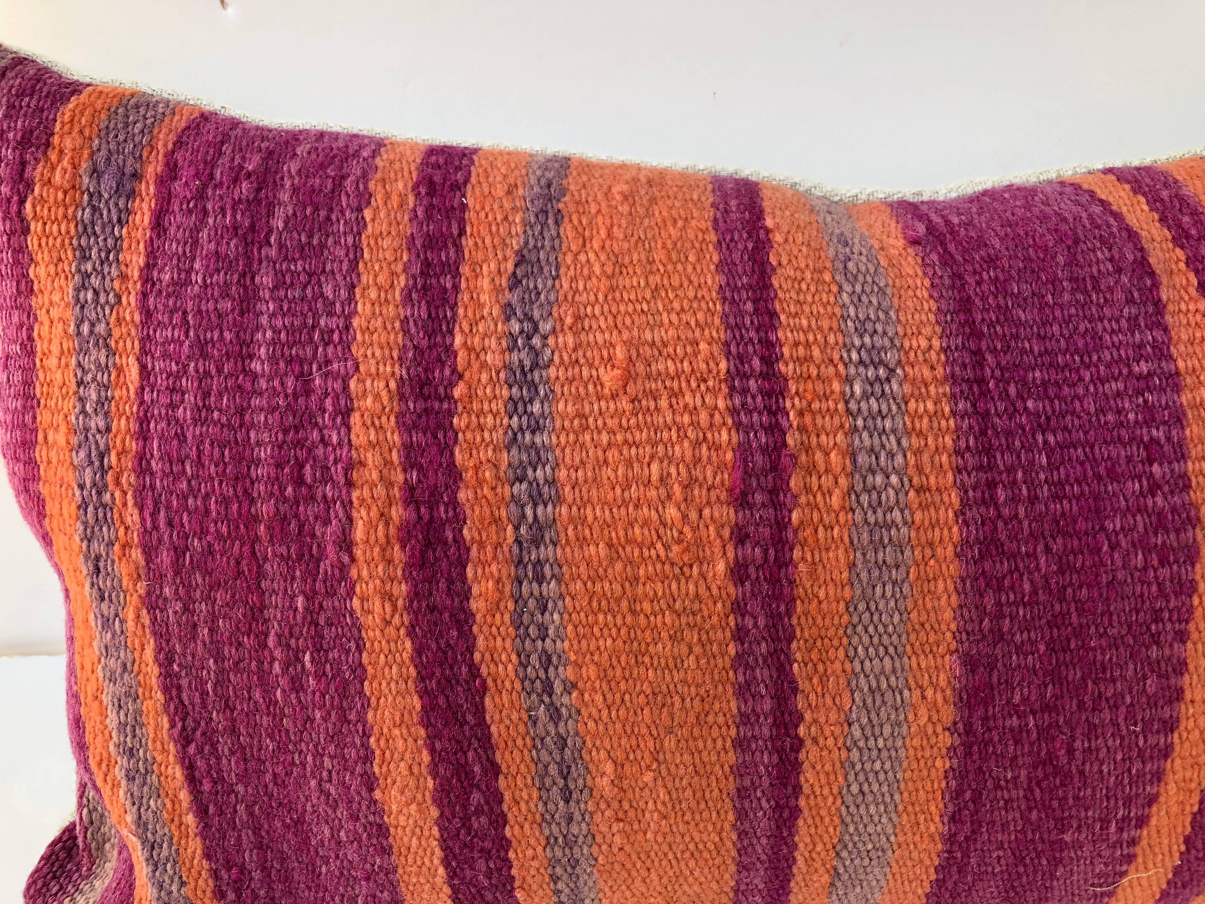 Custom pillow cut from a vintage Moroccan hand loomed wool Berber rug from the Atlas Mountains. Wool is soft and lustrous with colorful stripes. Pillow is backed in linen, filled with an insert of 50/50 down and feathers and hand sewn closed. We
