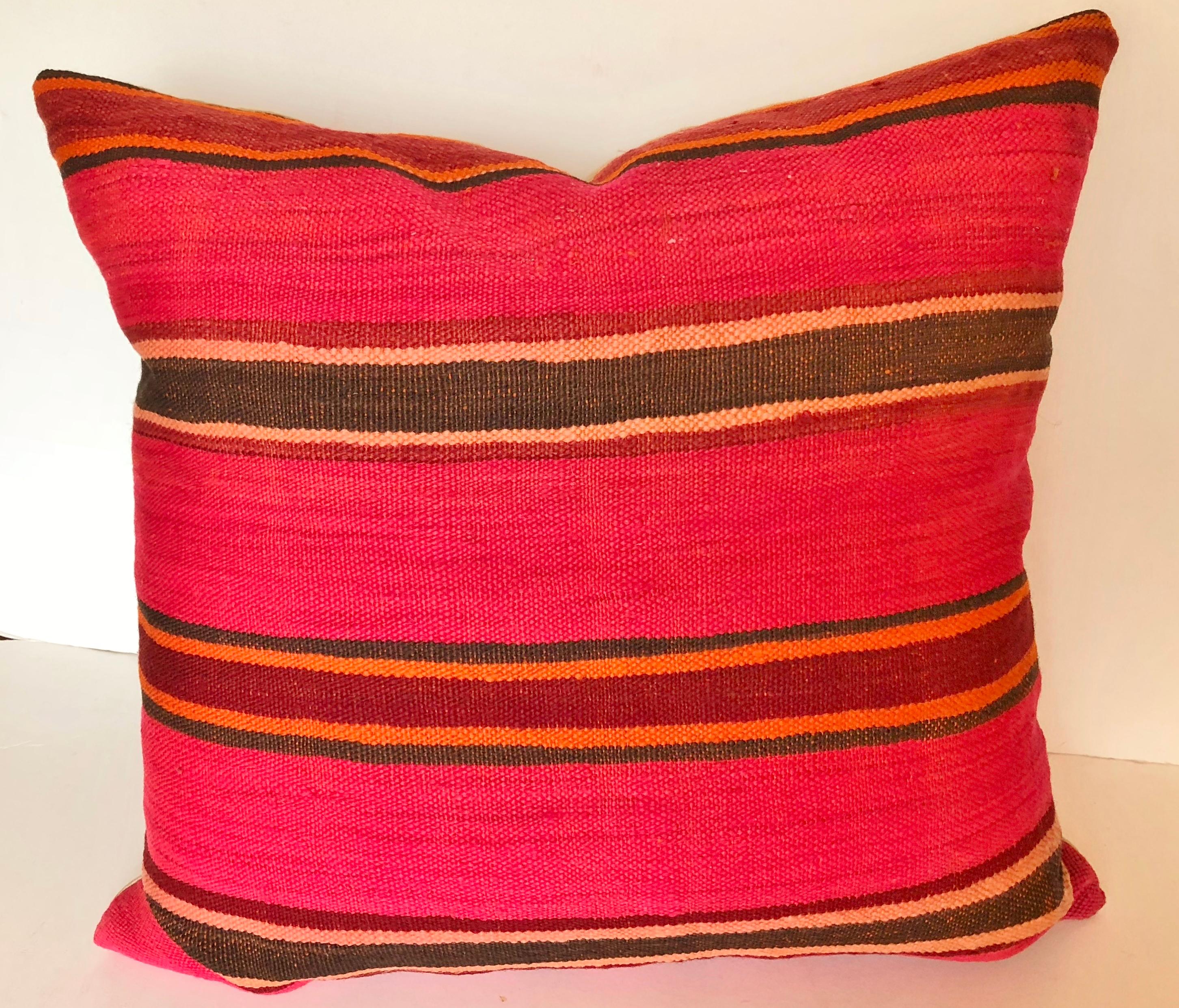 Custom pillow cut from a vintage Moroccan hand loomed wool Berber rug from the Atlas Mountains. Wool is soft with deep pink stripes. Pillow is backed in ivory silk, filled with an insert of 50/50 down and feathers and hand sewn closed. We make all