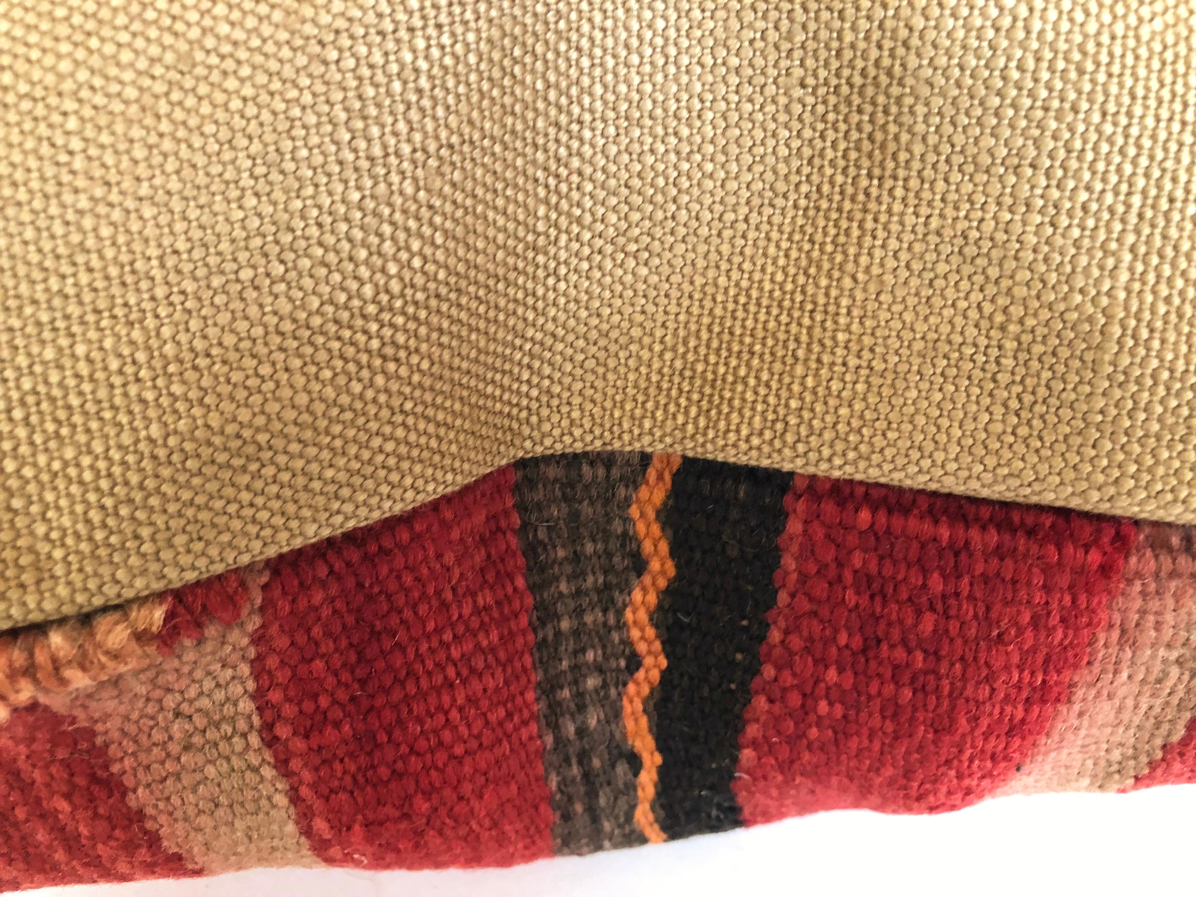 Custom pillow cut from a hand loomed wool Moroccan Berber rug from the Atlas Mountains. Wool is soft and lustrous with multicolored stripes and tufted tribal designs.
Pillow is backed in linen, filled with an insert of 50/50 down and feathers and