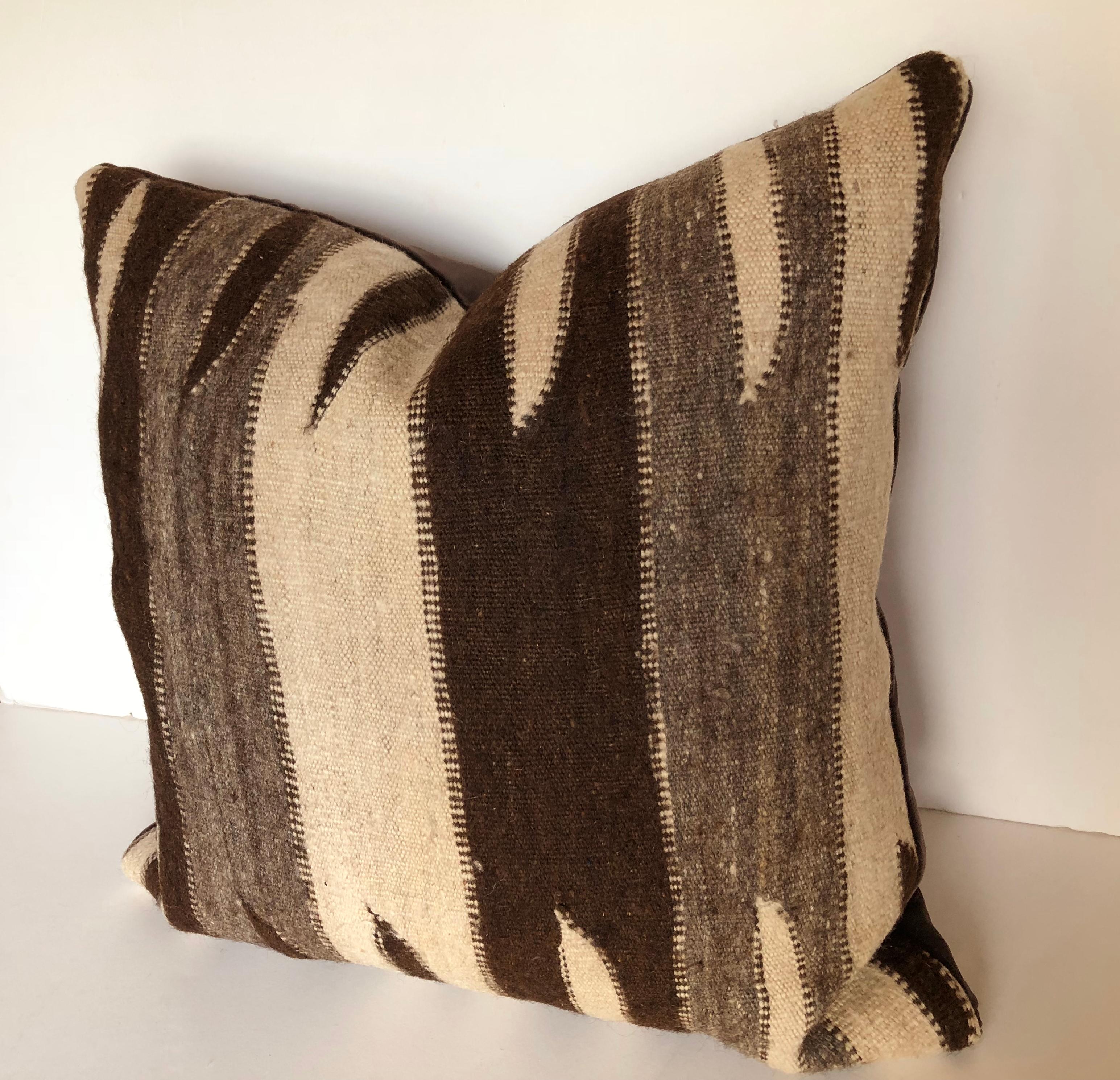 Custom pillow cut from a vintage Moroccan hand loomed wool rug from the Ourika Valley, Atlas Mountains. Wool is soft and lustrous, heavy weight with natural colors. Pillow is backed in down brown velvet with an insert of 50/50 down and feathers and