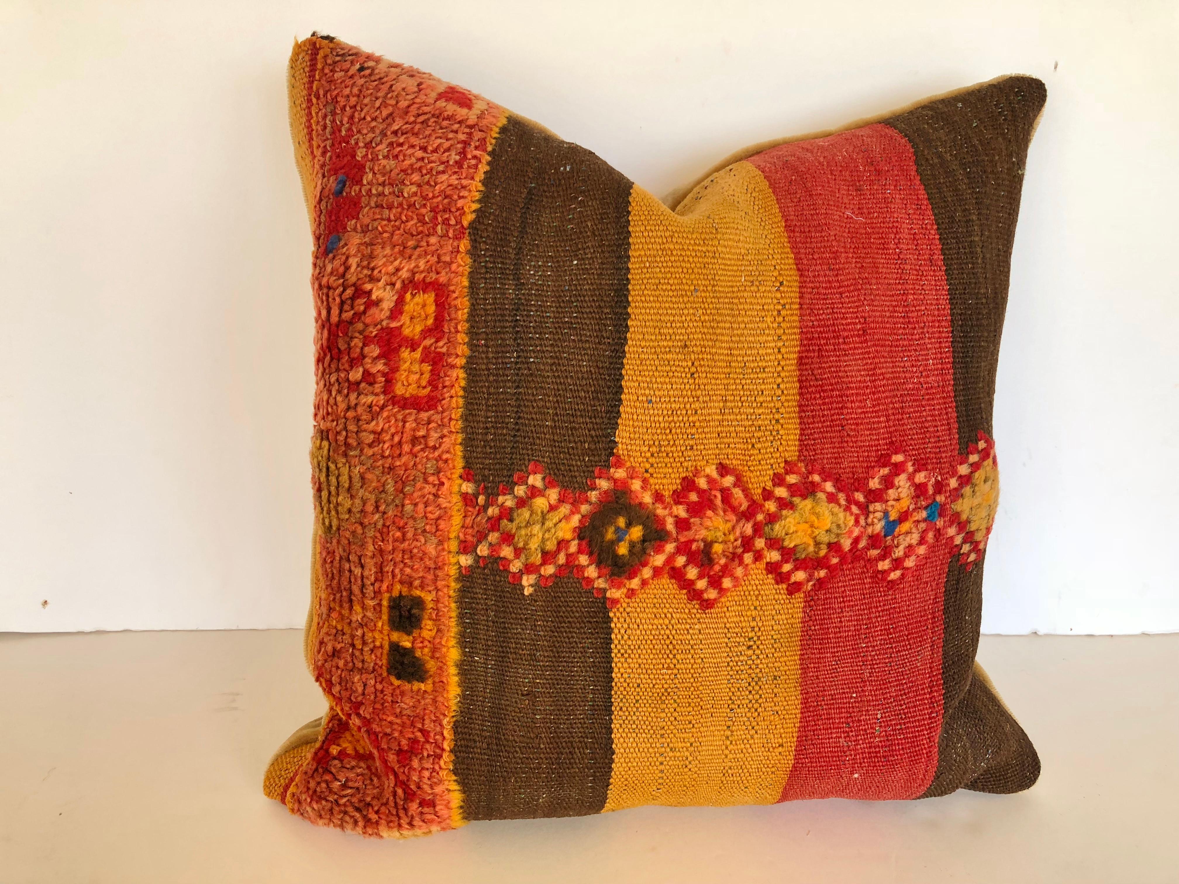 Custom pillow cut from a vintage hand loomed wool Moroccan Berber fug from the Atlas Mountains. Colorful stripes are embellished with tufted tribal designs. Pillow is backed in mohair, filled with an insert of 50/50 down and feathers and hand sewn