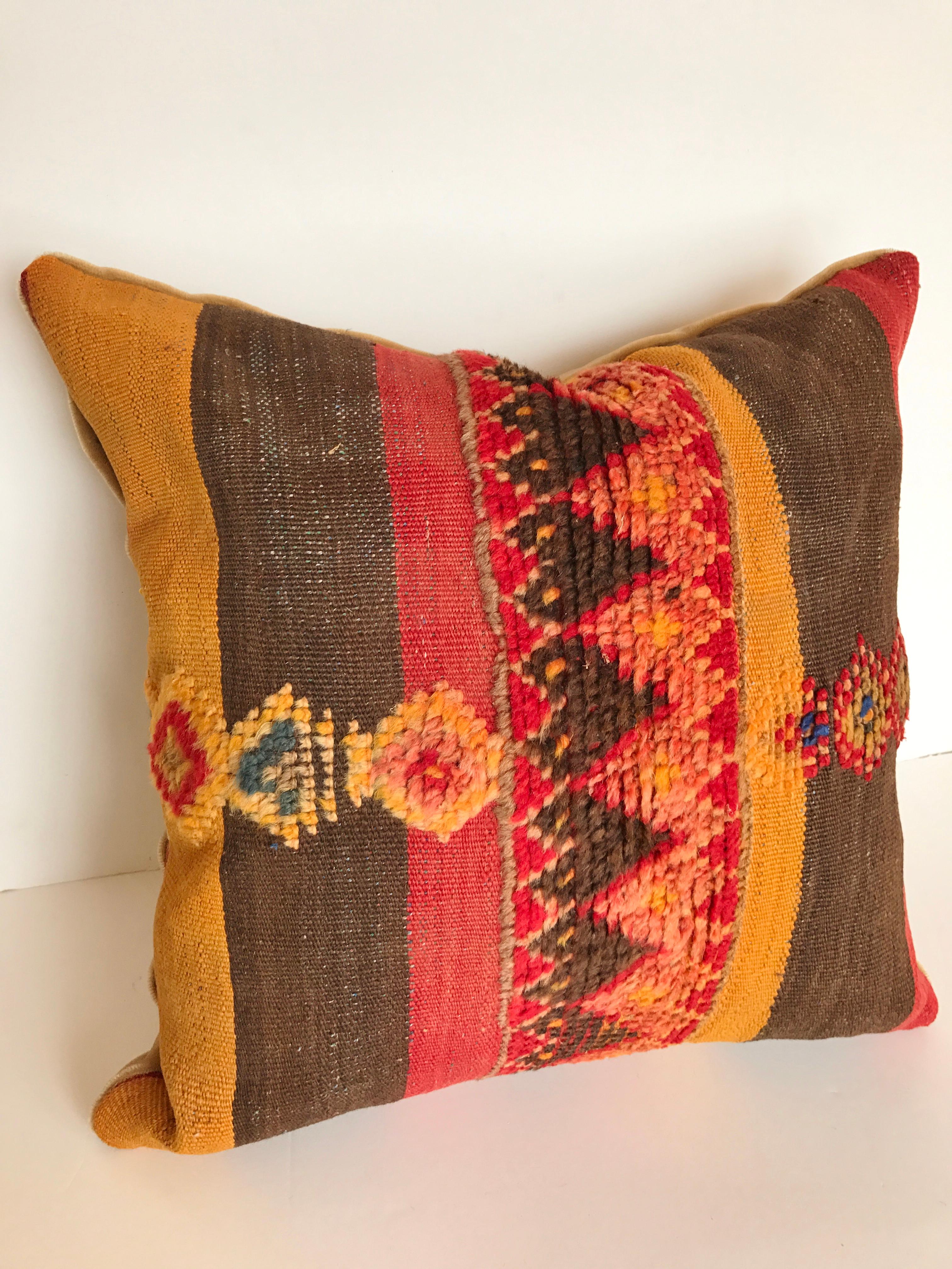 Custom pillow cut from a vintage hand loomed wool Moroccan Berber rug from the Atlas Mountains. Colorful stripes are embellished with tufted tribal designs. Pillow is backed in mohair, filled with an insert of 50/50 down and feathers and hand sewn