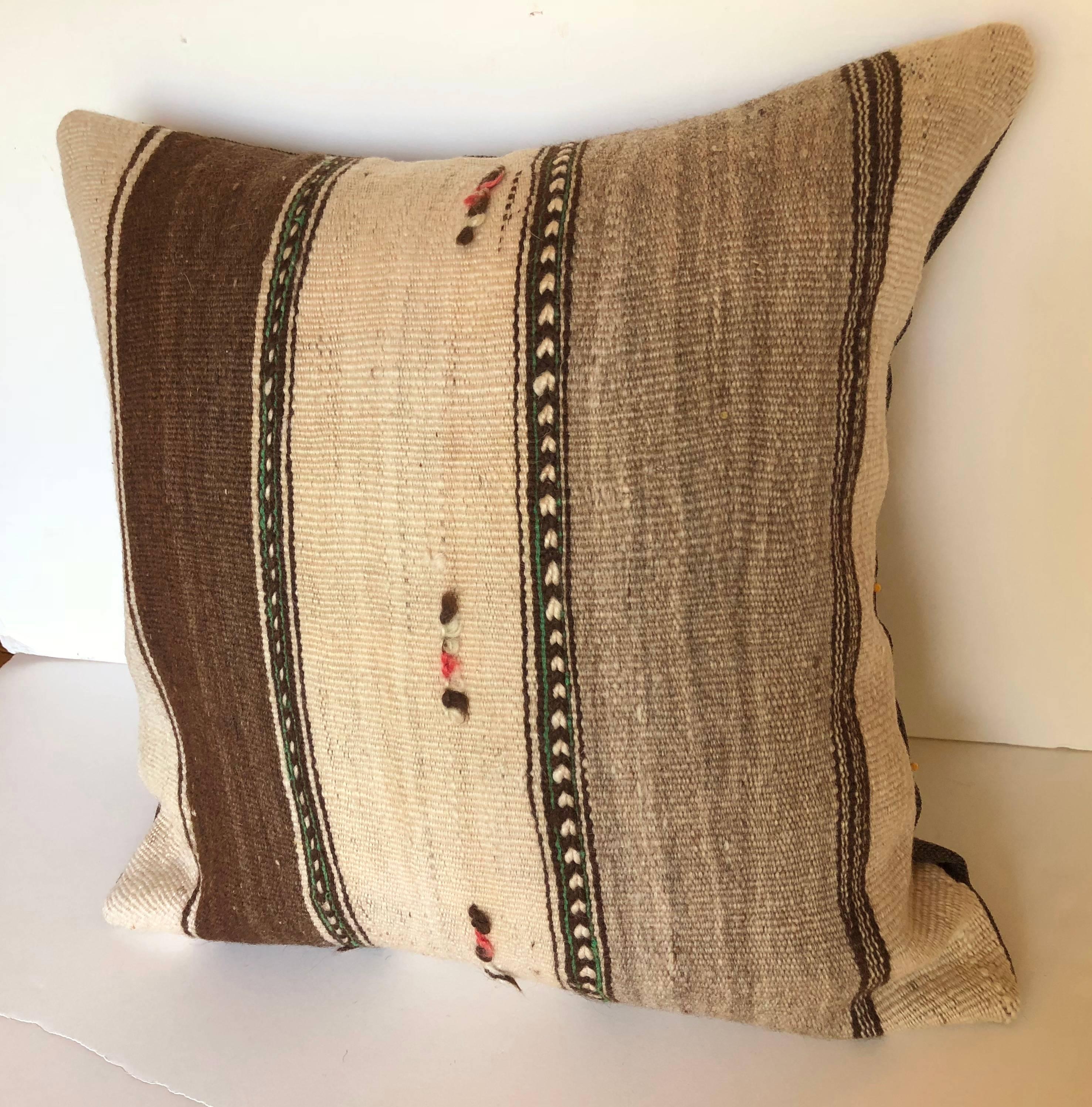 Custom pillows cut from a vintage Moroccan hand loomed wool Berber rug from the Atlas Mountains. Wool is soft and lustrous with stripes in natural colors. Pillows are backed in a brown linen blend, filled with an insert of 50/50 down and feathers