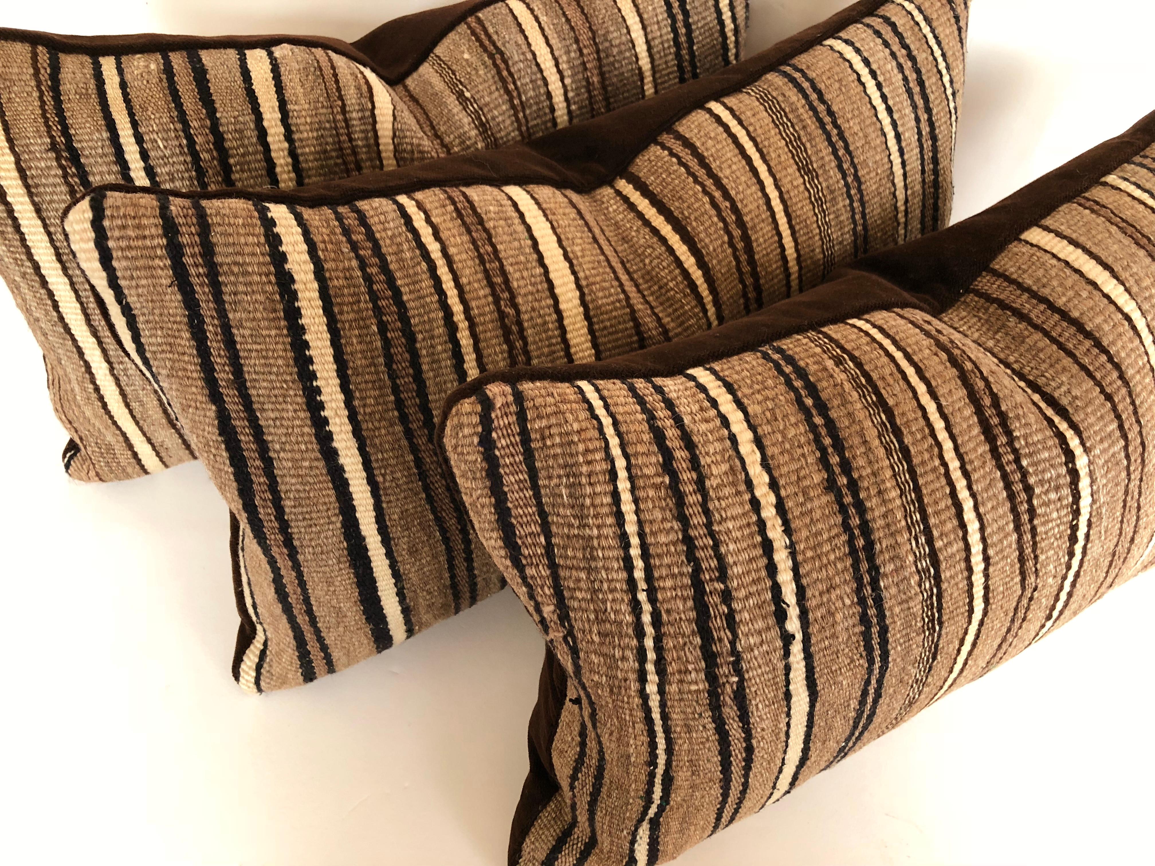 Custom pillows cut from a vintage hand loomed wool Moroccan Berber rug from the Atlas Mountains. Wool is soft and lustrous with arrow stripes in shades of brown with a touch of ivory and deep navy. Pillows are filled with an insert of 50/50 down and