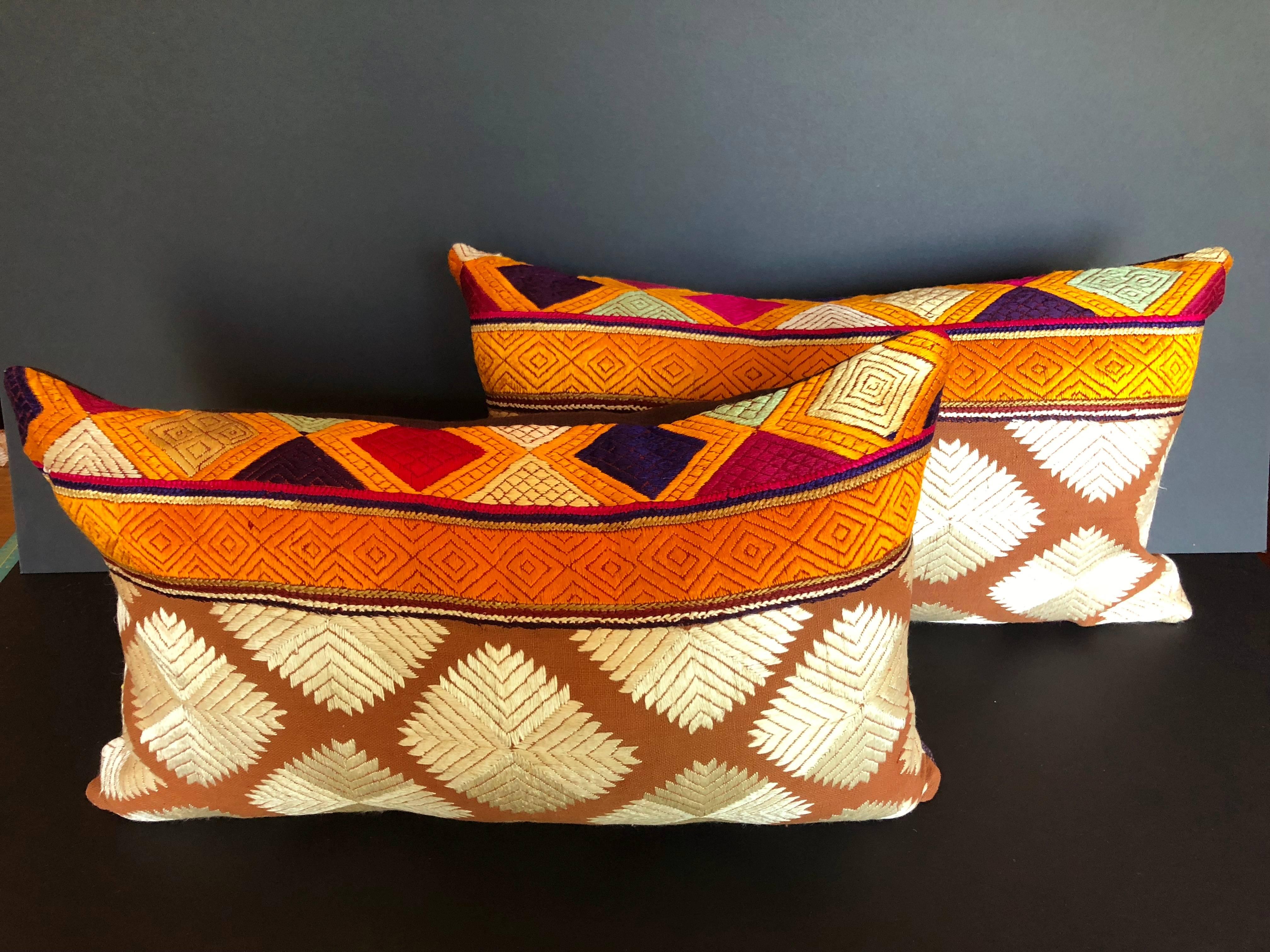 Custom pillows cut from a vintage Phulkari Bagh wedding shawl from Punjab, India. The hand loomed cotton khadi cloth is hand embroidered with silk threads in vibrant colors. Pillows are backed in a dark purple linen, filled with an insert of 50/50