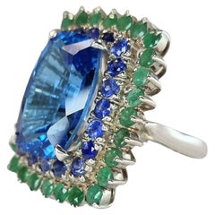 Custom Platinum Blue Topaz Cocktail Ring with Emerald and Sapphire Halo