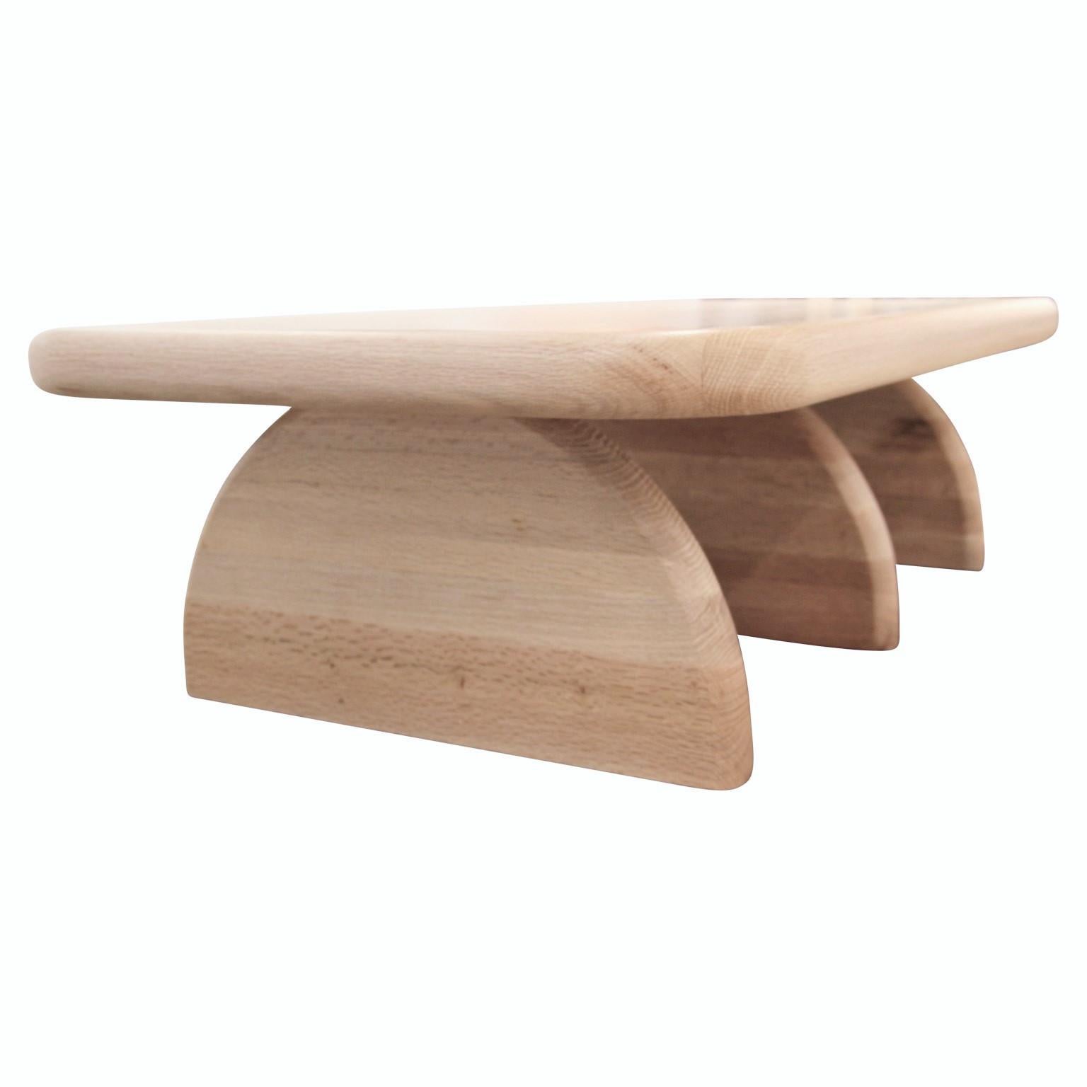 Custom post modern white oak coffee table that is sculpted to create a soft and organic form. The table has a clear finish that accentuates the oak's grain pattern.