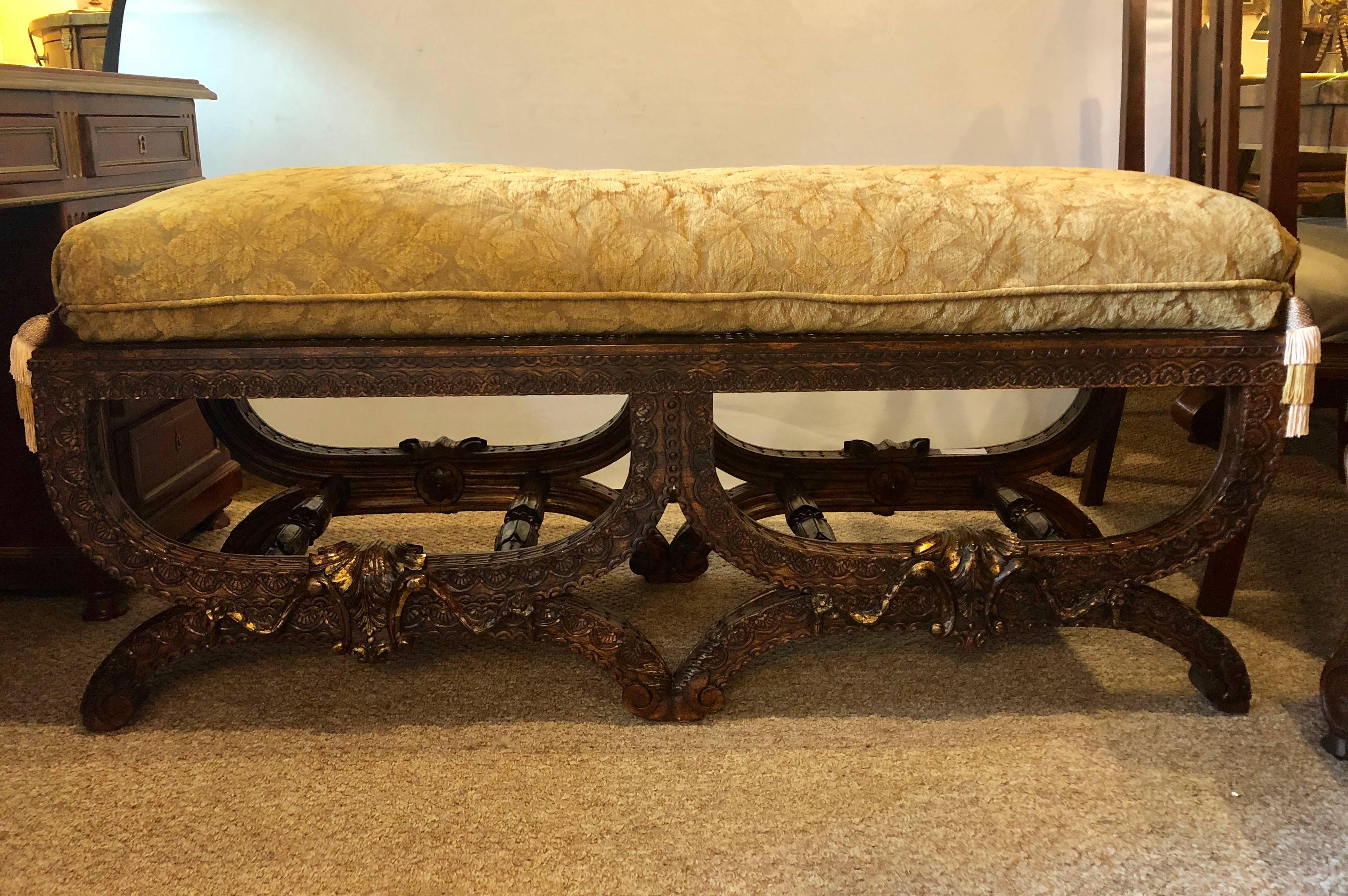 Custom quality walnut window bench finely carved with custom cushion. A wonderfully double X form walnut heavily carved in fine detail window or footrest bench with a custom quality cushion. This bench leaving nothing to the imagination should you