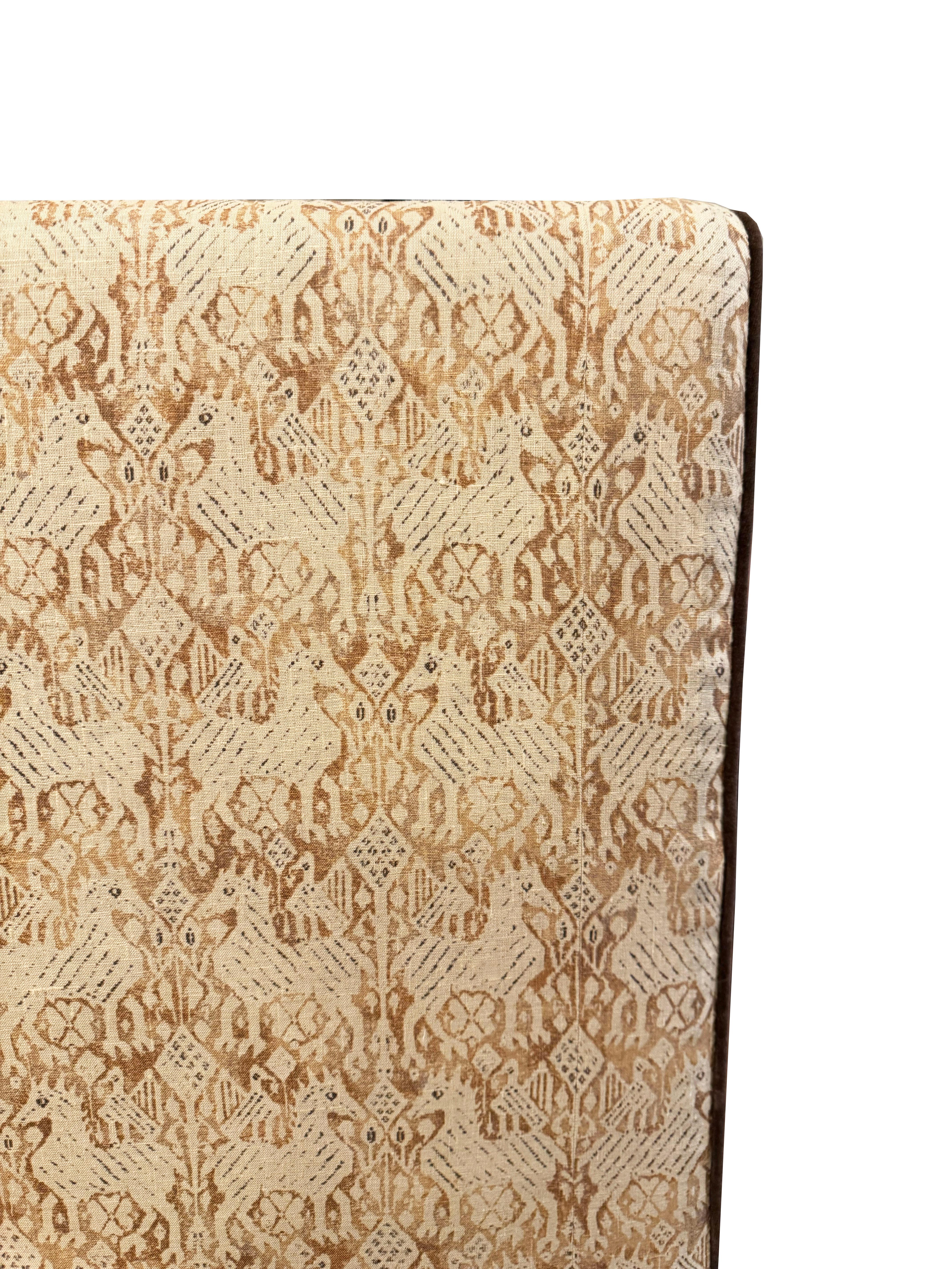 Élevez votre chambre à coucher avec cette exquise tête de lit rembourrée Custom Queen, dotée d'un luxueux textile Rose Tarlow orné d'un passepoil en velours marron contrasté. Ce qui rend cette pièce vraiment exceptionnelle, c'est le tissu rare et