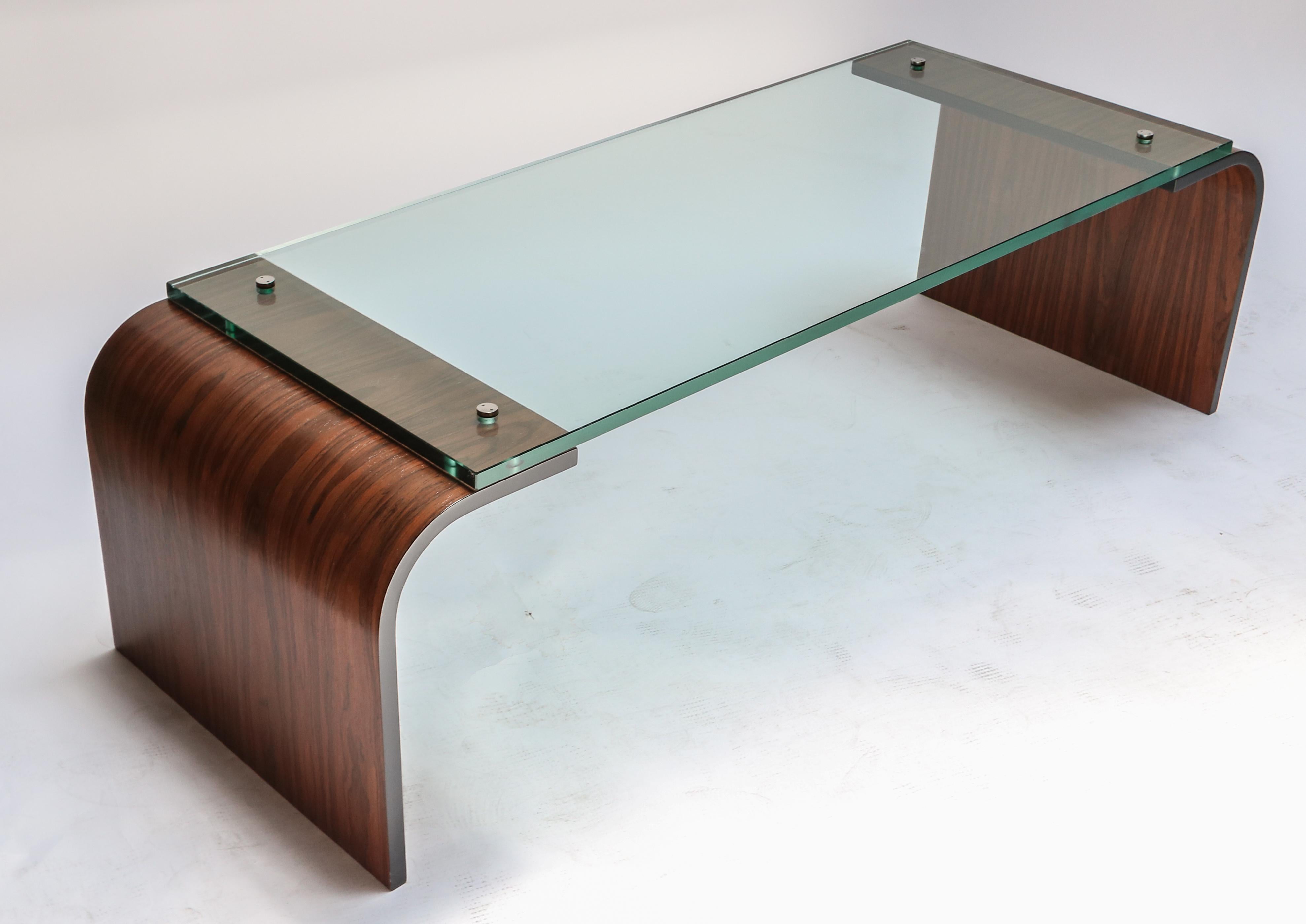 Custom coffee table with curved rosewood ends and glass top attached with handmade decorative metal screws.  Made in Los Angeles by Adesso Imports.

Can be done in different sizes and finishes. Priced individually.