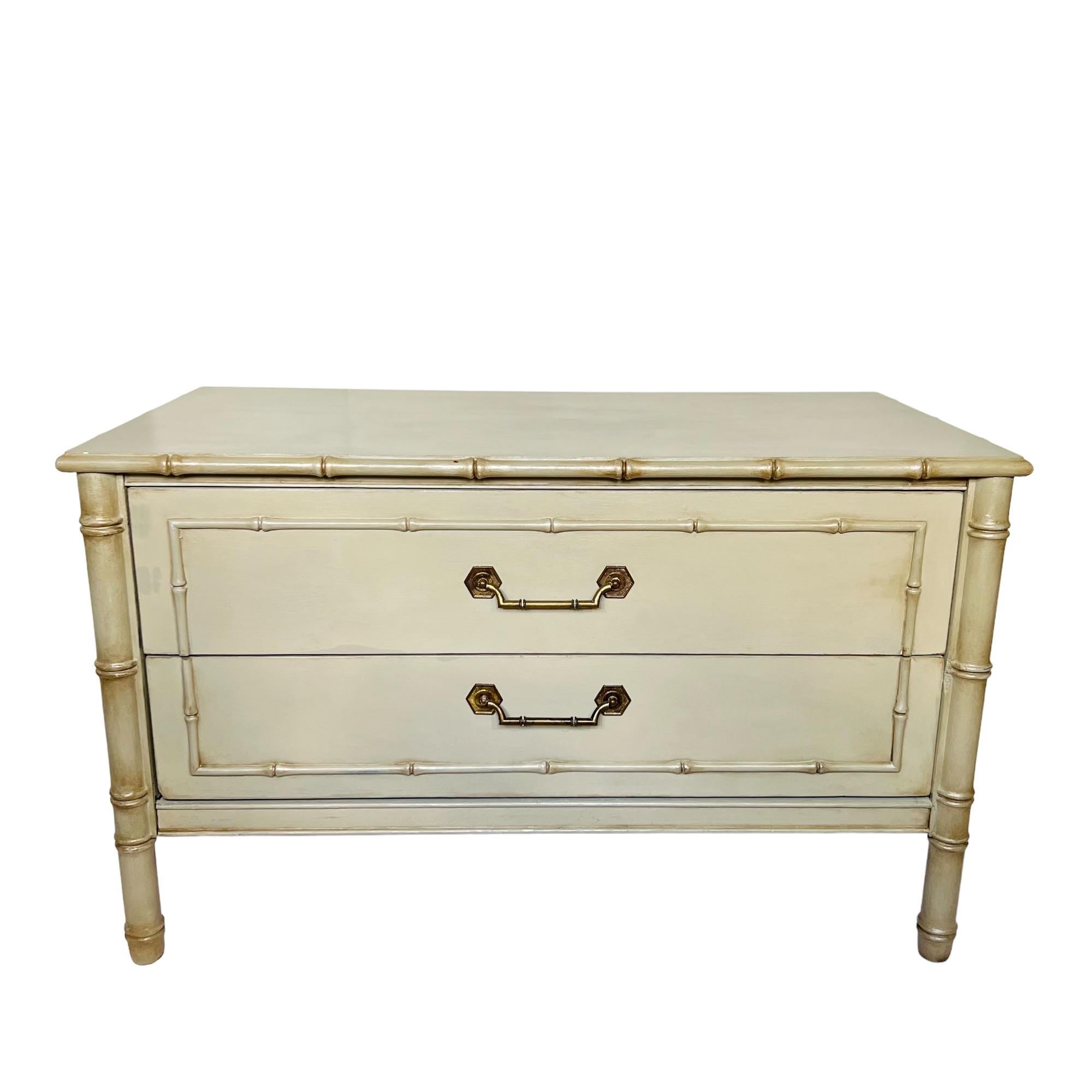 This vintage Thomasville Palm Beach Regency faux bamboo chest of drawers has been custom refinished in satin light grayish green with pearlescent highlights and dark wax details. It features two drawers adorned with brass handles and lined in gray