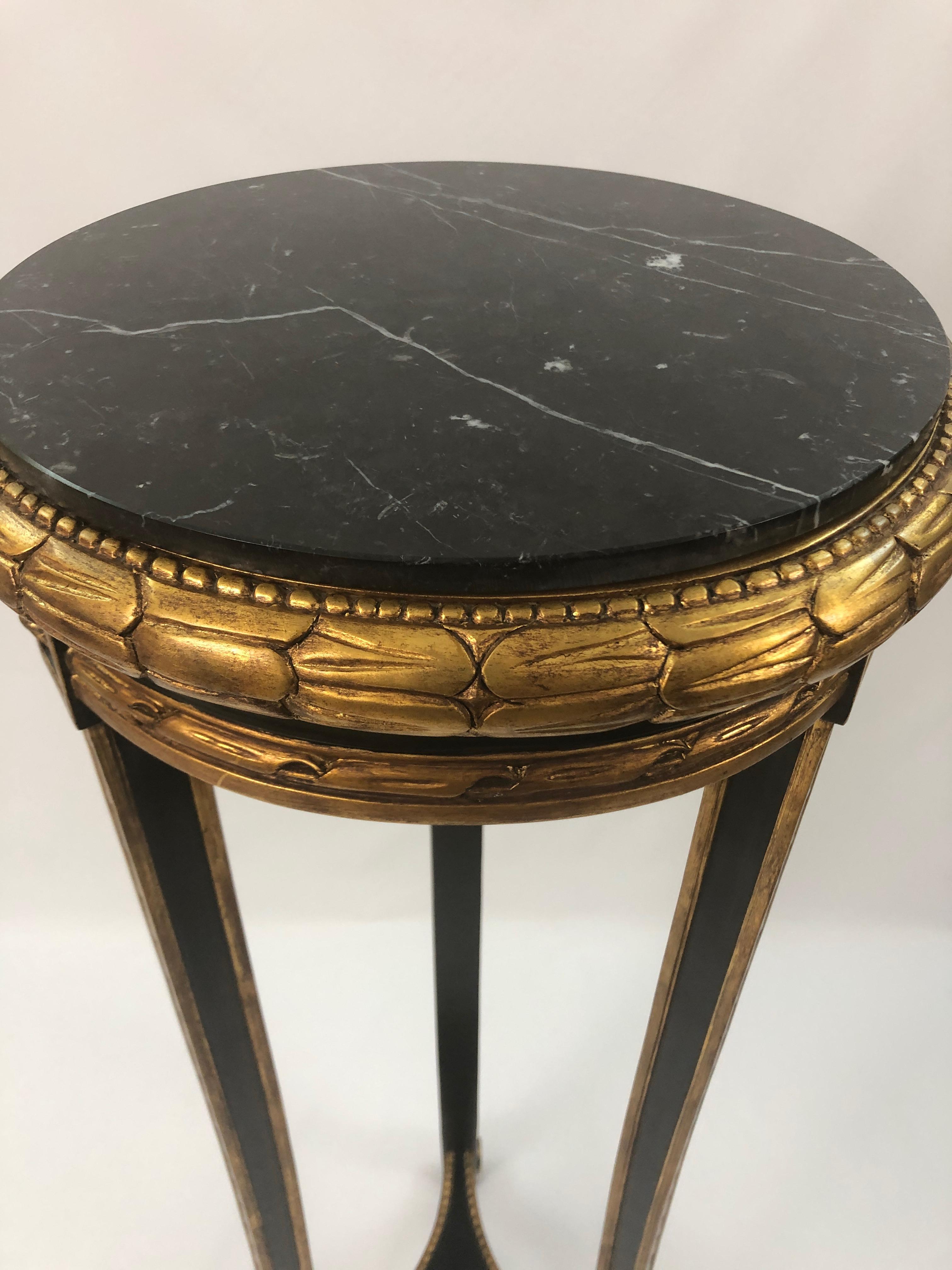 Beautiful Regency style ebonized and gilded stand having black and white veined marble top.