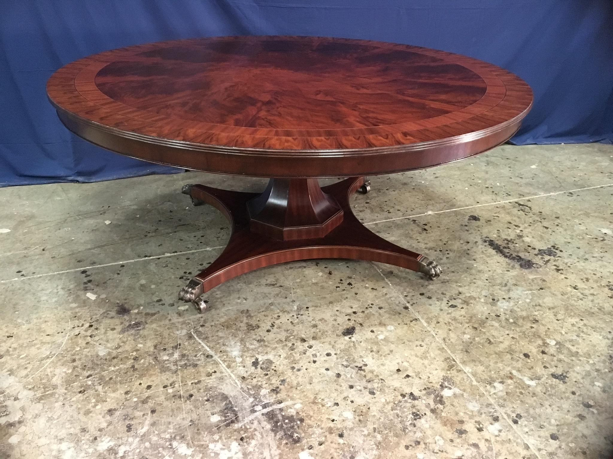 This is made-to-order large round traditional mahogany dining table made in the Leighton Hall shop. It features a radial cut field of west African swirly crotch mahogany and two borders of straight grain mahogany and santos rosewood. It has a hand