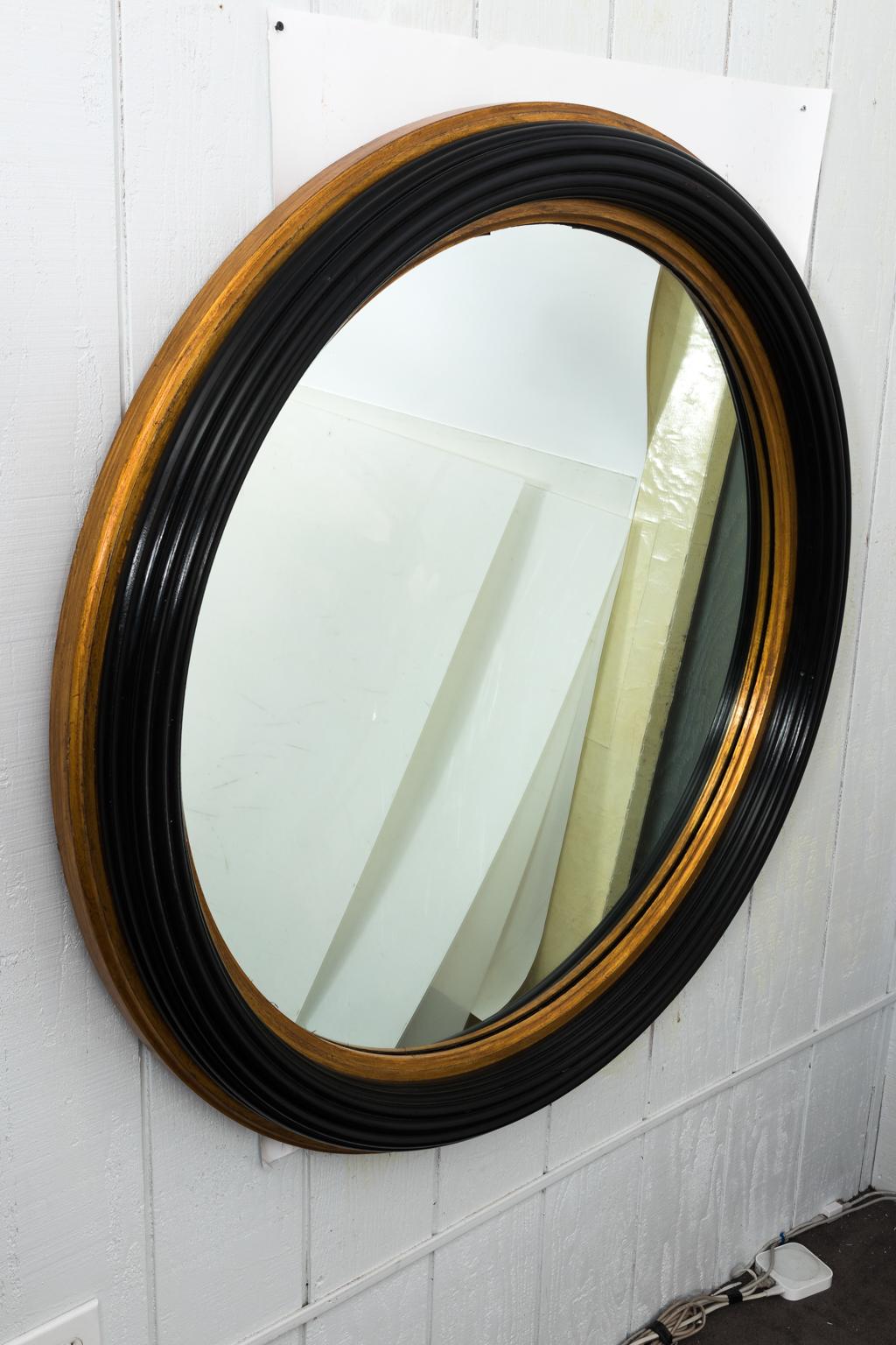 Custom designer round ridged mahogany mirror in black with gold gilt accent trim. Please note of minor chips to the frame due to wear with use.
 