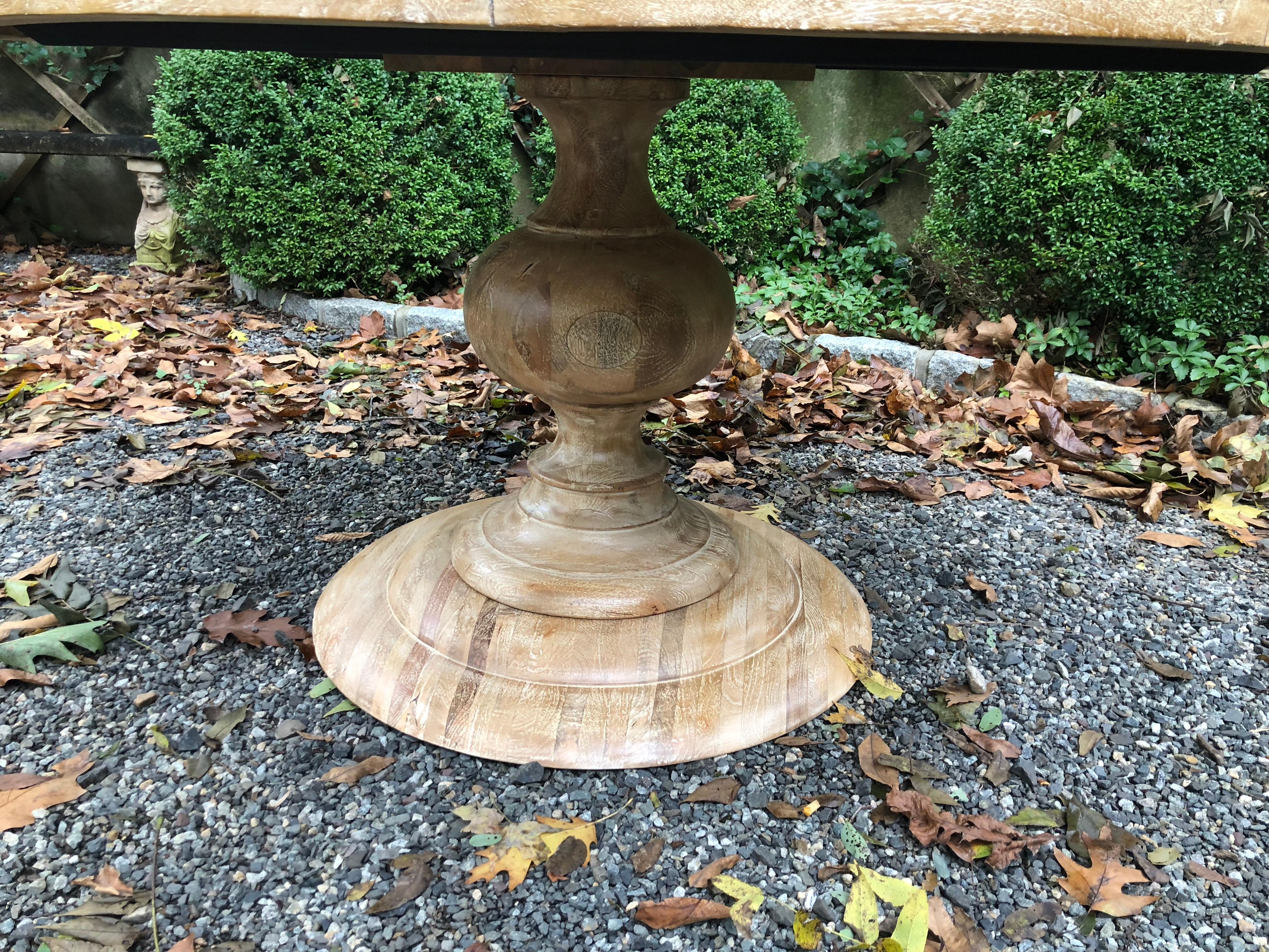 A custom made bleached elm pedestal table with an urn shaped base. The wood in this Classic table has a beautiful grain and the circular detail of the solid wood pedestal base adds to the table’s sophisticated look.