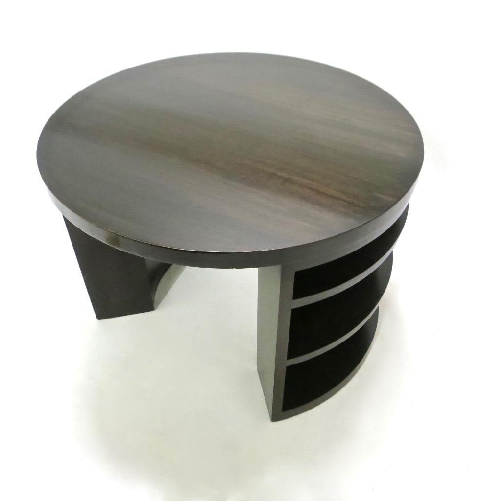 Round, custom-made wooden center table in a deep brown finish with two symmetrical sections of exposed, arc-shaped shelves and two symmetrical open sides.