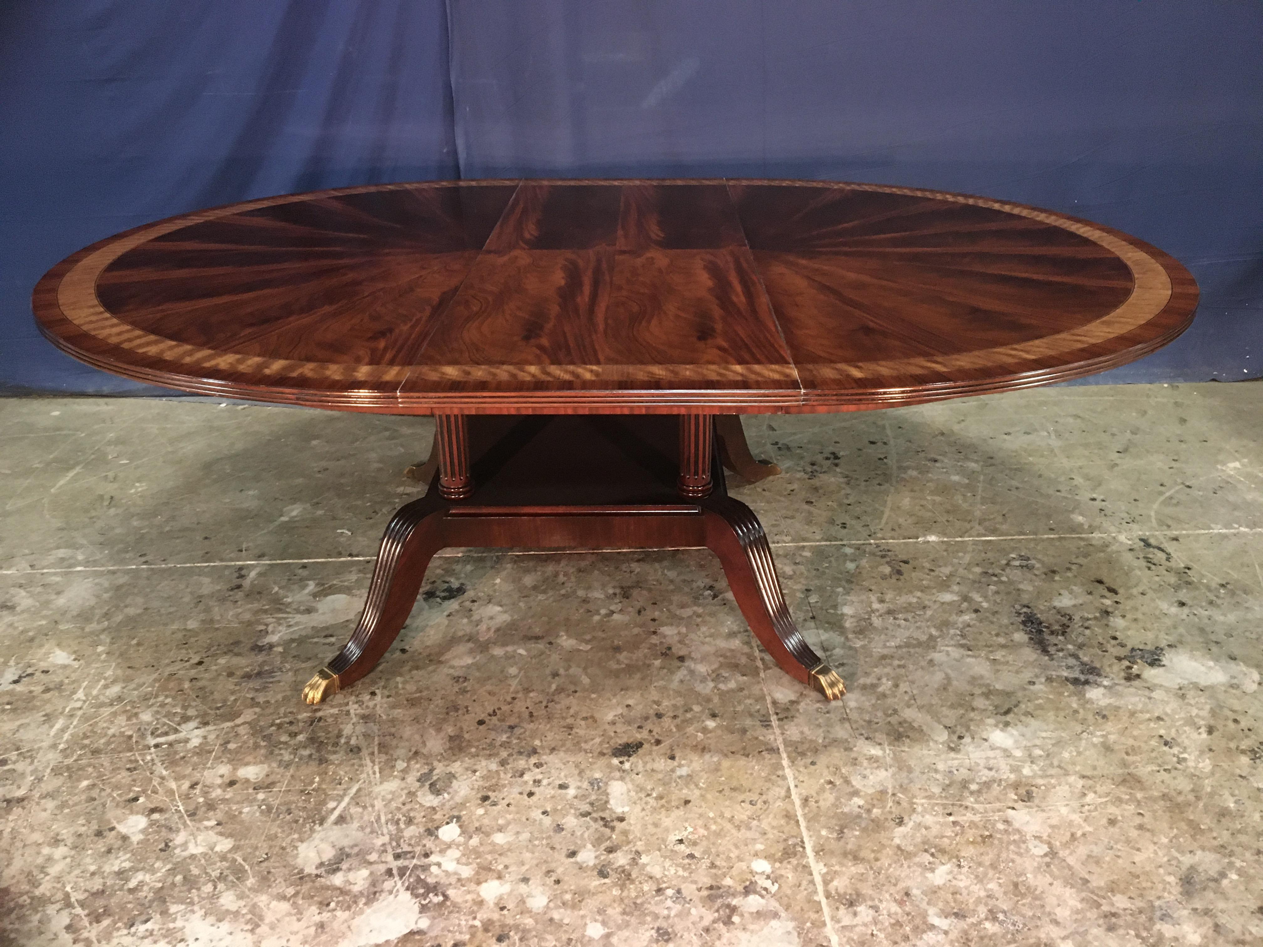 This is made-to-order round traditional mahogany dining table made in the Leighton Hall shop. It features a radial cut field of West African swirly crotch mahogany and two borders of satinwood and Pau Ferro.  The top has a medium brown mahogany