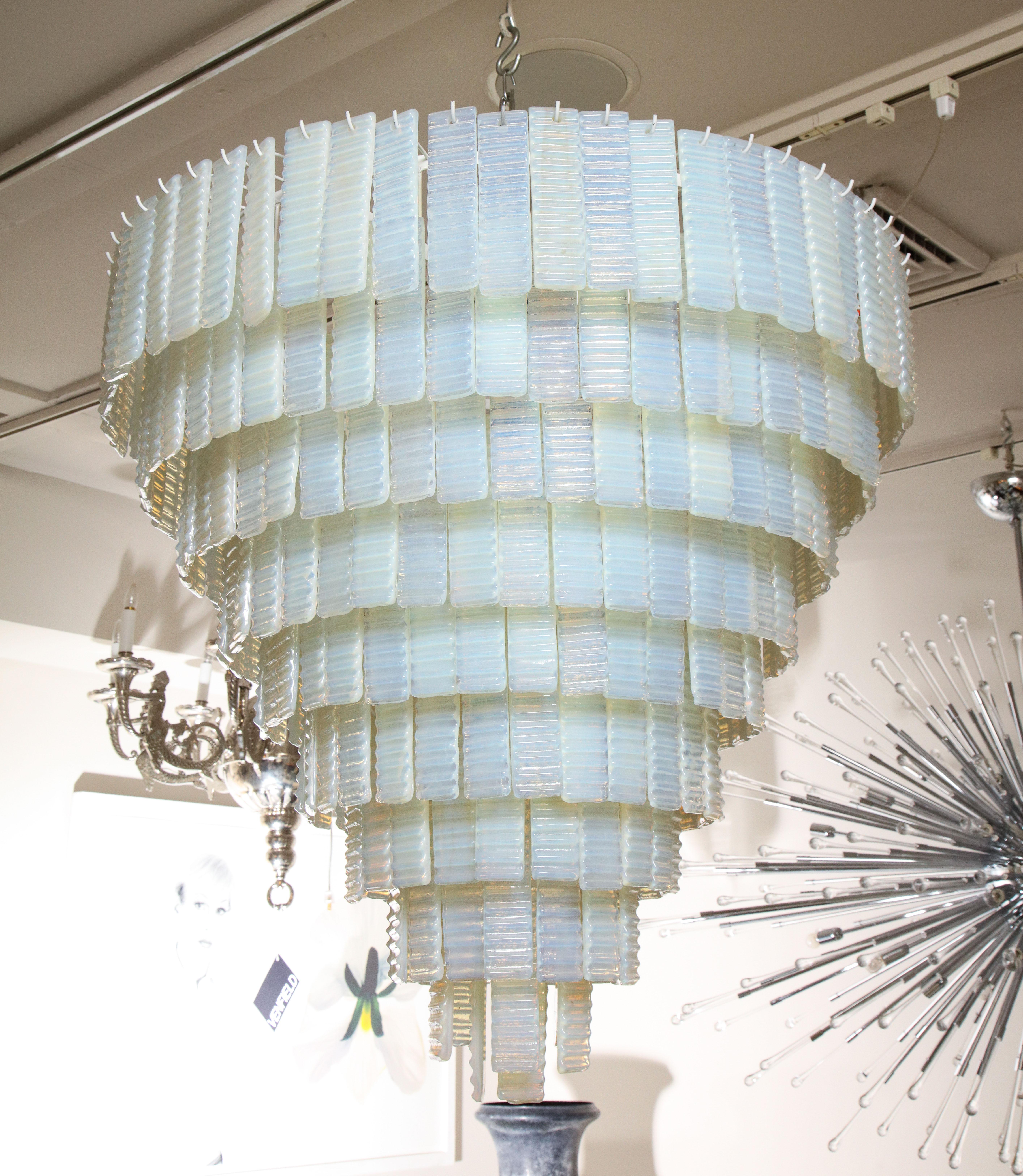 10 tiered corrugated opalescent Murano glass chandelier in a round shape available for immediate purchase. Custom orders are also available for different sizes, shapes, finishes and glass colors. Please specify your preference of pole or chain for a