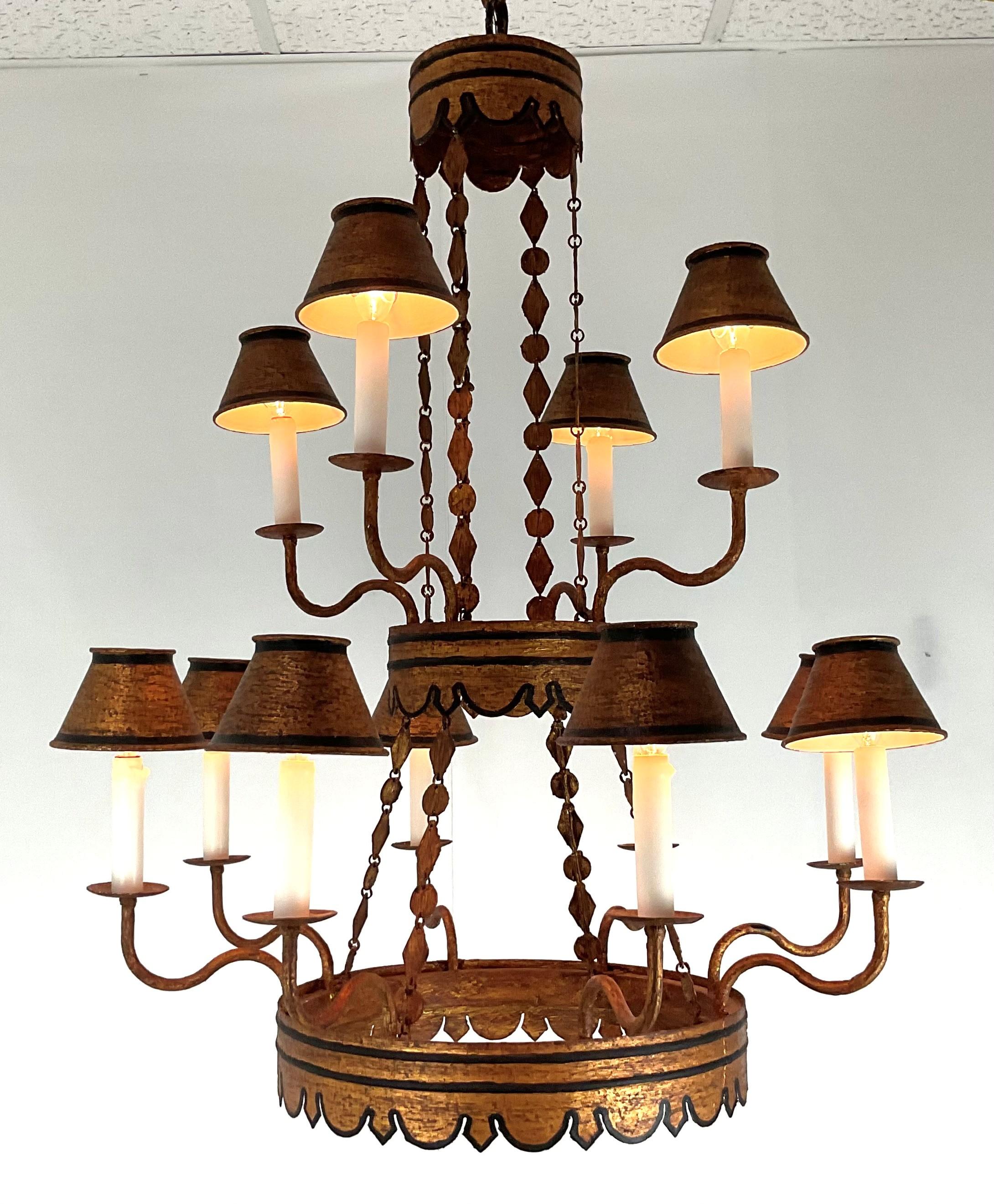 Bring warmth, whimsy, and Old-World style to any interior with this delightful vintage twelve-light tole chandelier. Beautifully created in iron with hand-painted tole accents, the fixture showcases a rich, warm patina in tones of ochre and deep