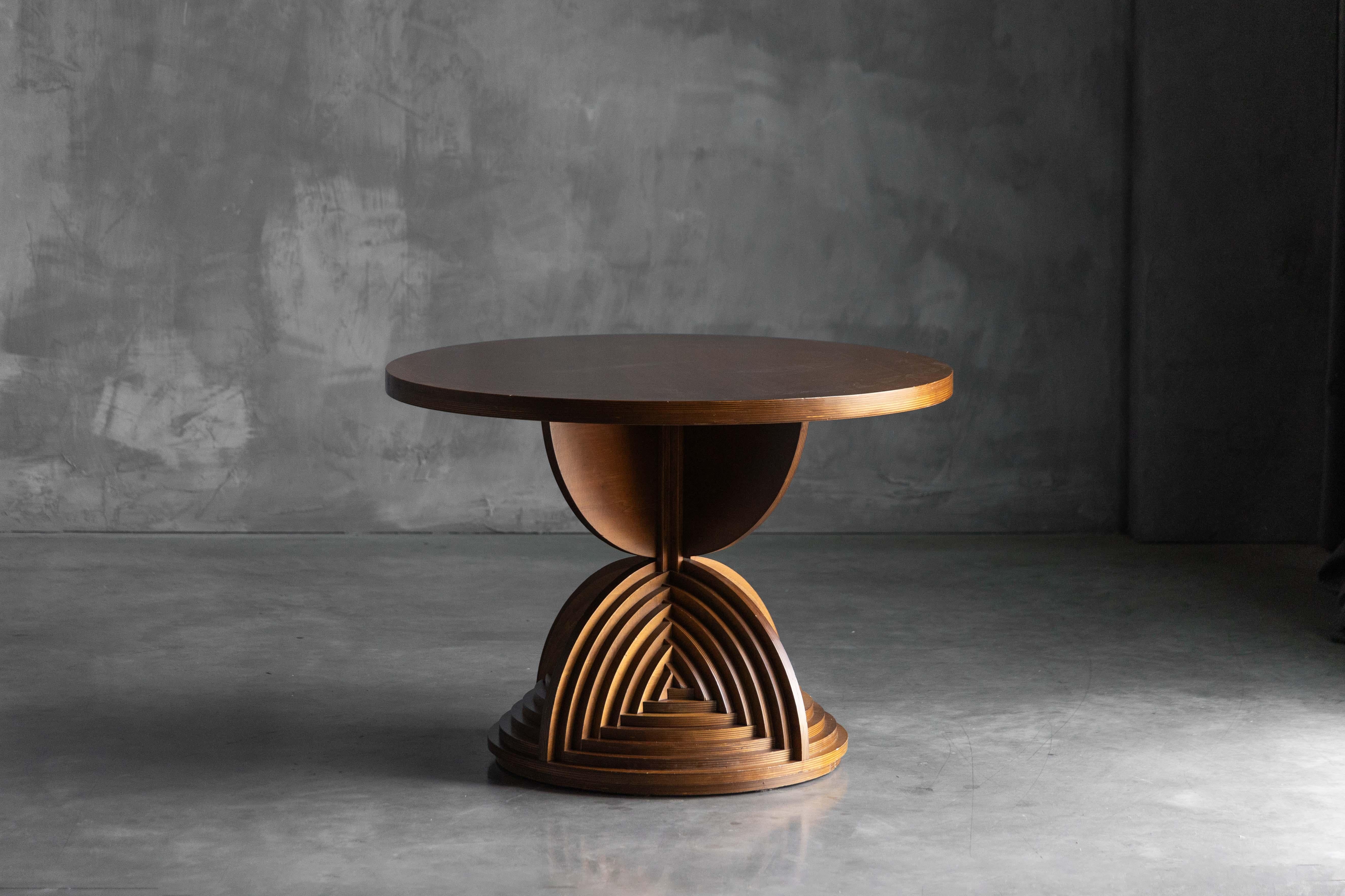 Sculptural table designed by Mario Ceroli in the 1970s, a unique custom-made piece that embodies the artist’s expressive and architectural language. Crafted entirely from wood, the table features a striking curved base composed of layered arches,