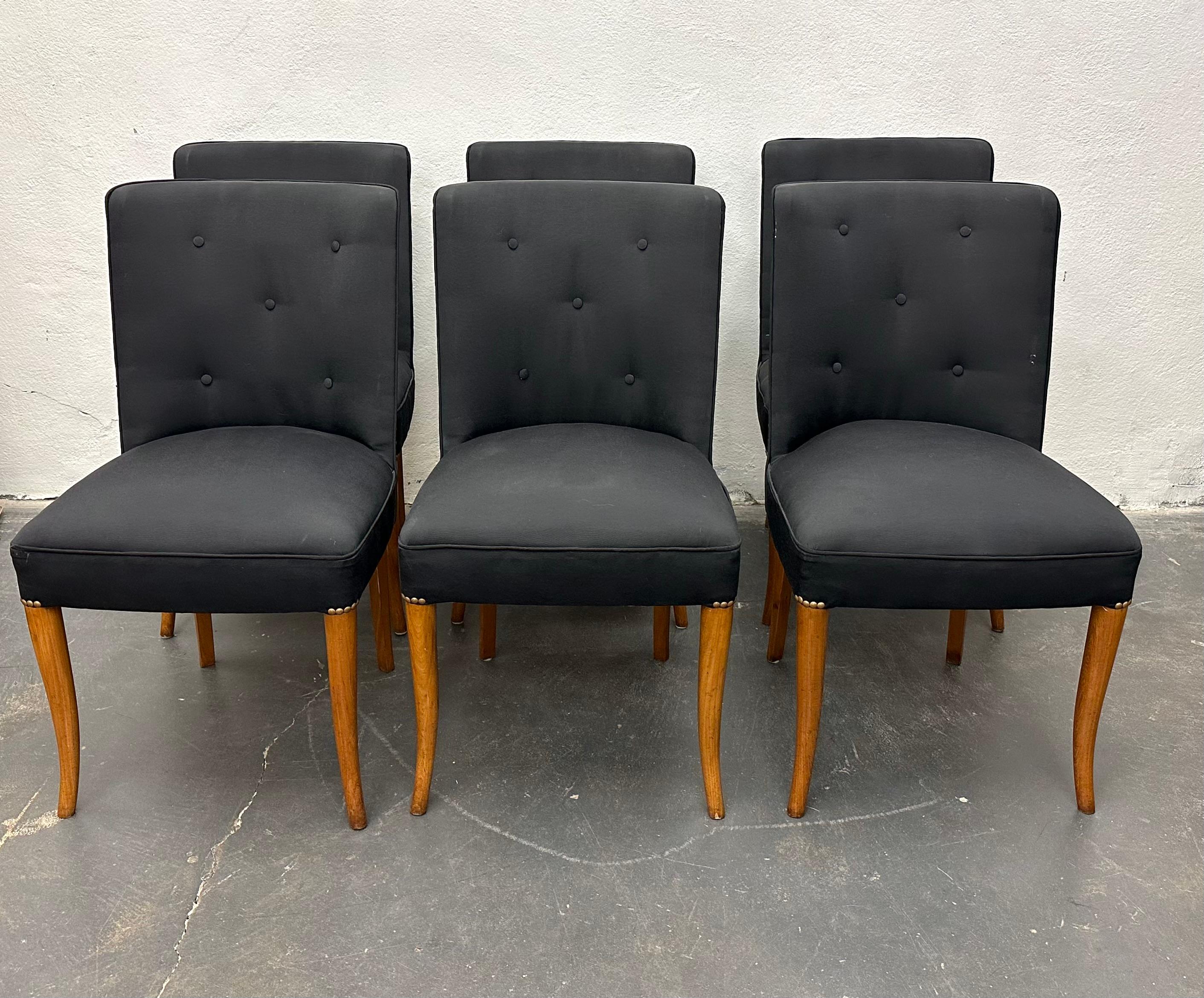 Set of six dining chairs with black silk-upholstered barrel-backed seats with brass rivets on elegantly sabred bleached walnut legs, circa 1930s. From the estate of Alan Moss.