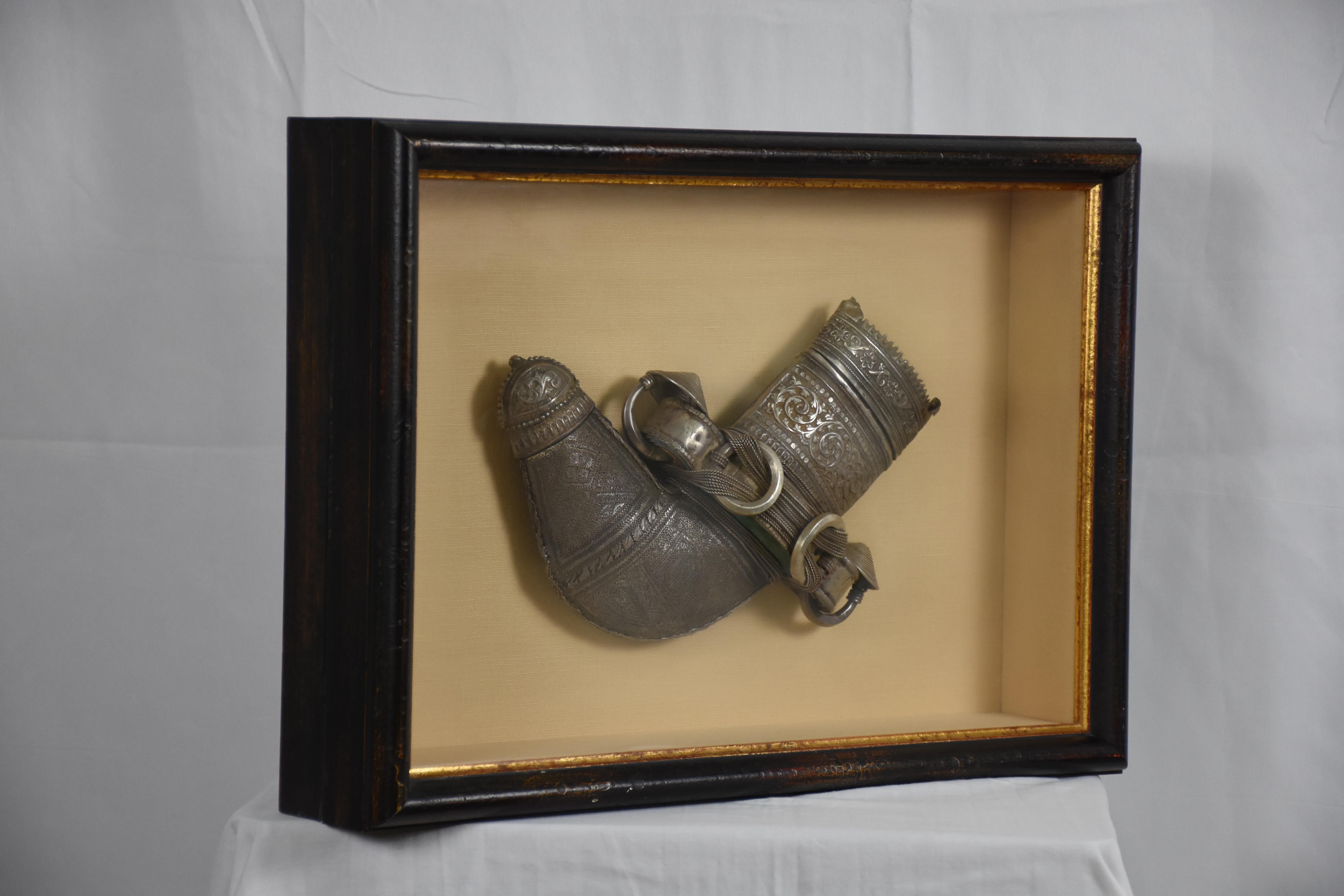 Cette boîte d'ombrage remarquable présente un fourreau antique de Najran, une région historique du sud de l'Arabie saoudite connue pour ses riches traditions artisanales et son savoir-faire interculturel. Le fourreau, qui date probablement de la fin