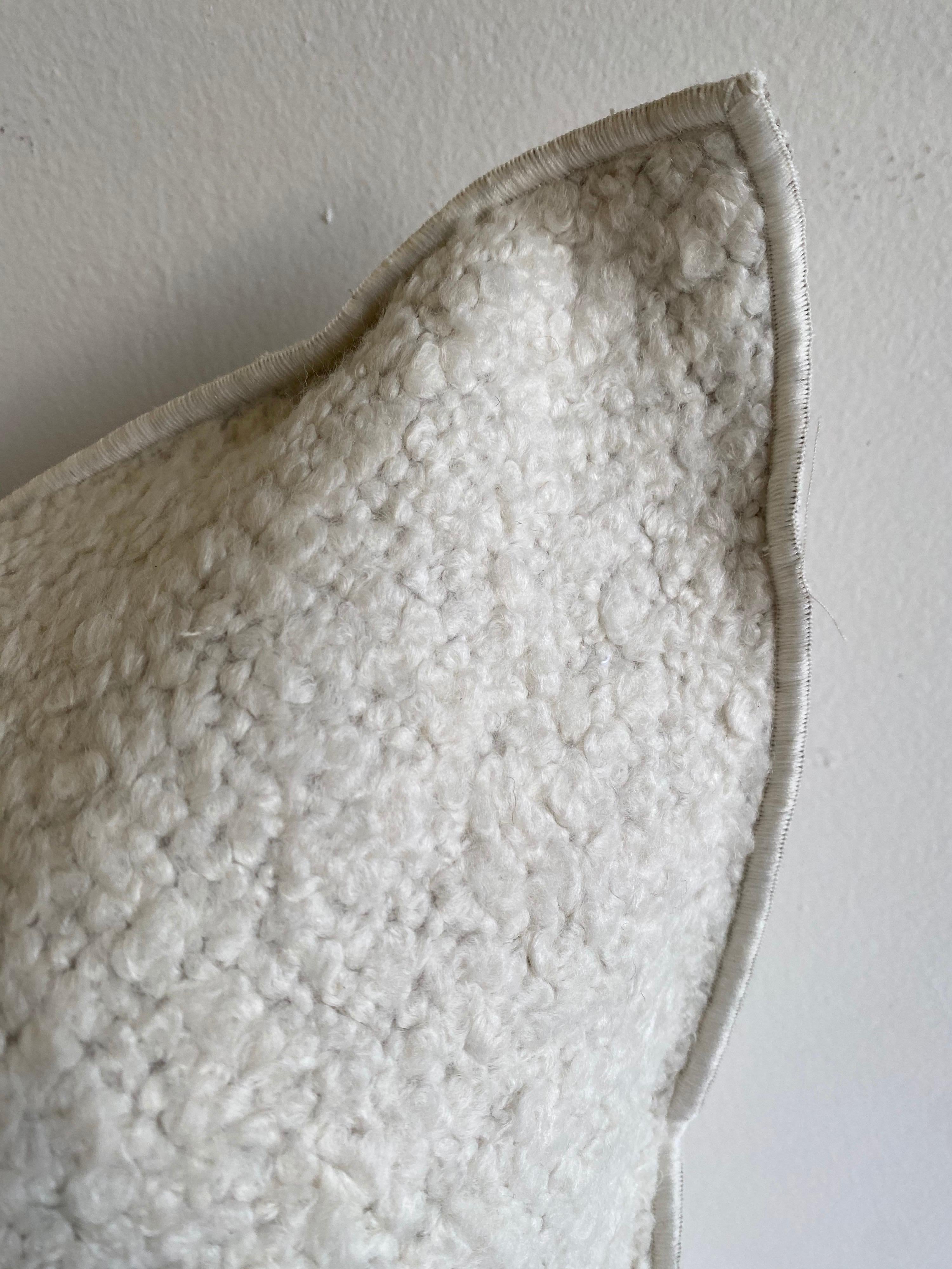 Oreiller d'appoint en laine et lin mélangés avec insert en duvet Couleur : Toile Yeti / Blanc Un oreiller en forme de boucle de couleur blanc crème avec un bord surpiqué, fermeture à glissière en métal. Nos oreillers sont fabriqués à partir de