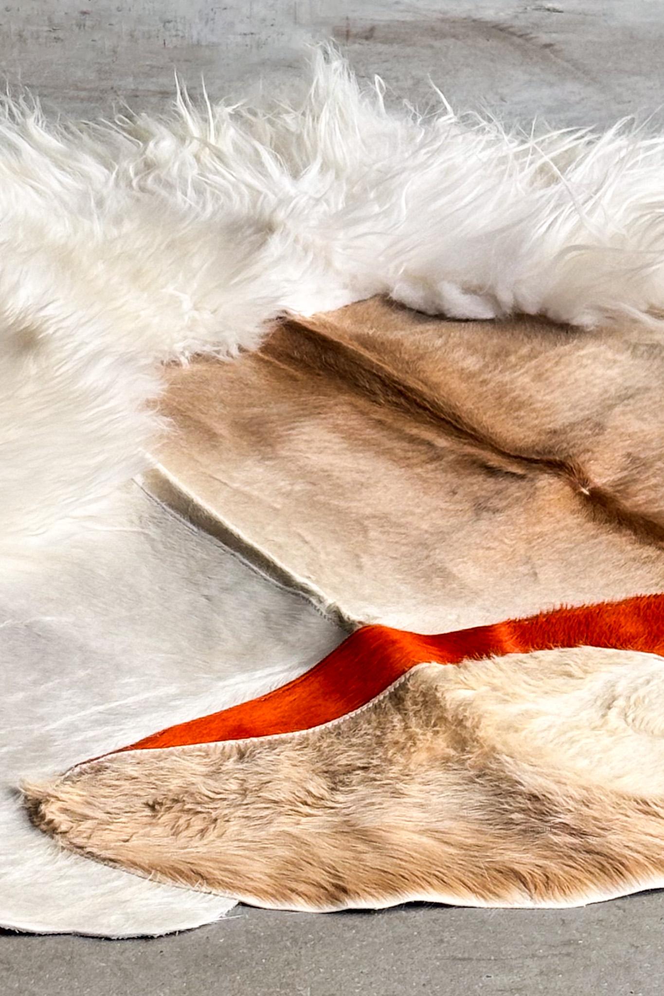 Dieser unverwechselbare Teppich von Carine Boxy ist aus einer Mischung natürlicher Tierhäute, darunter weiches Schaffell, gefertigt und zeigt ein auffälliges Zusammenspiel von Texturen und Farbtönen. Leuchtend orangefarbene Akzente unterstreichen