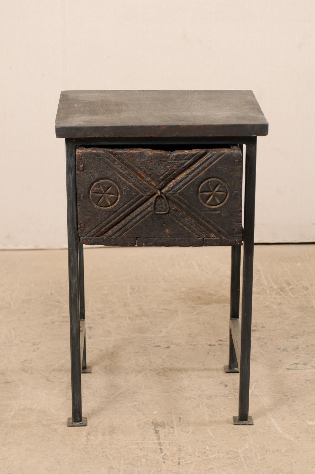 A small-sized side chest with 18th century Spanish door. This unique and custom designed side chest features an 18th century (or earlier) Spanish carved wood drawer, with a reclaimed wood top above, all set within a custom iron base. The drawer