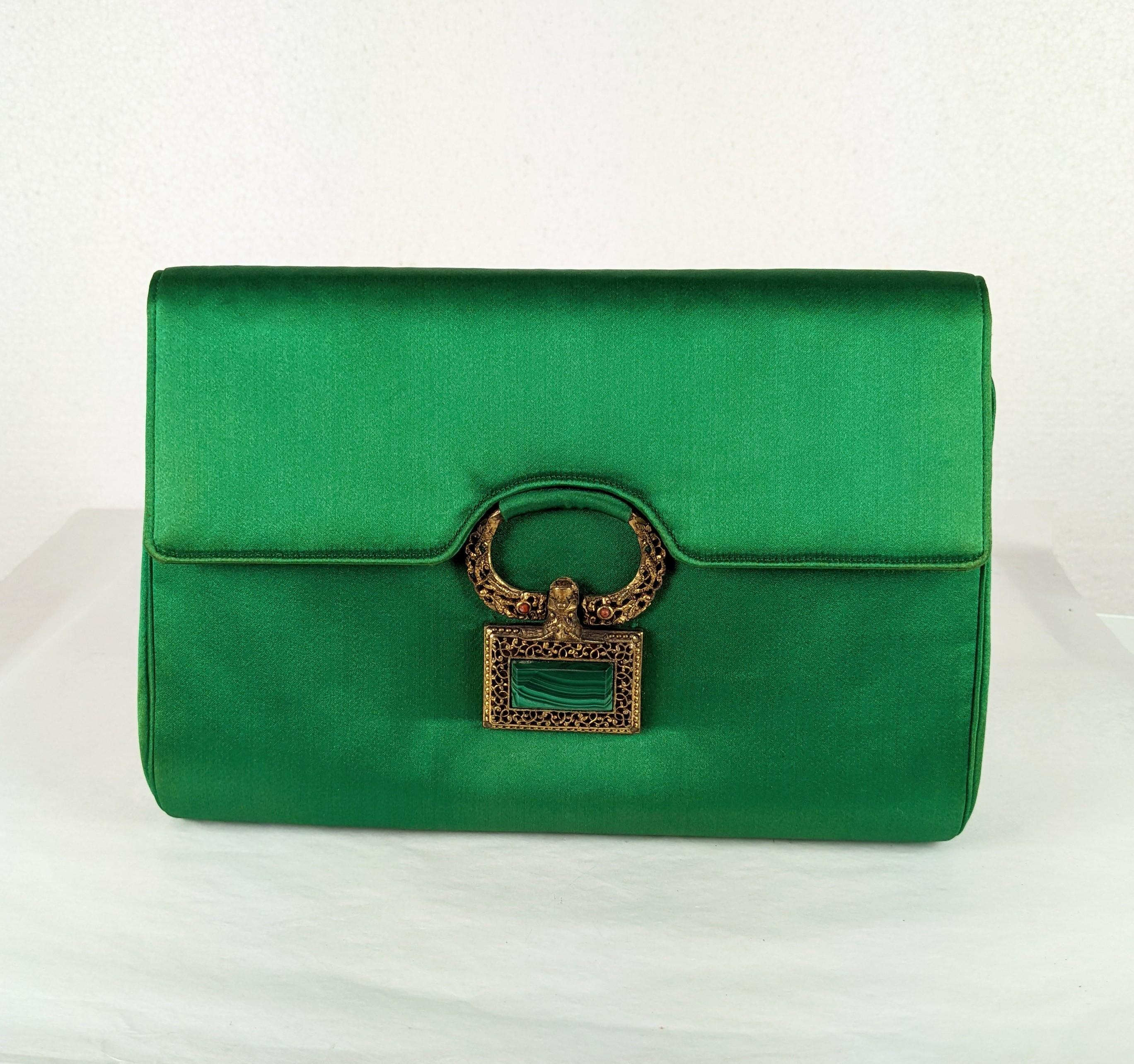 Custom Silk Satin Clutch with Malachite and Coral from the 1960's. Emerald silk satin is lined in peach satin with antique clasp of Asian origin with coral cabs and a large genuine malachite slab. Label: Anton Moritz NY. 1960's USA.
8.5