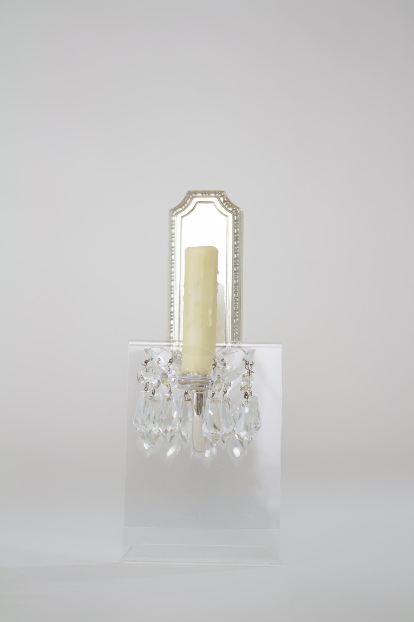 Custom silver plate sconces with crystals. These sconces have a narrow backplate, made to mount over a switch plate box, a declicate arm that curves up to hold a crystal bobeche and plug shaped crystal prisms. The crystal parts are all high quality