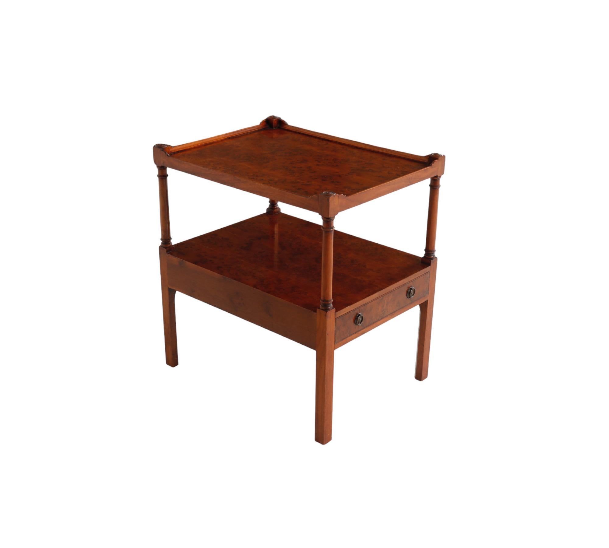 An English style two tier side table, custom made by Smith & Watson of New York. Top corners are finished with beveled circles. Below is a single dovetailed drawer that opens with two round metal handles. Decorated throughout with birdseye maple