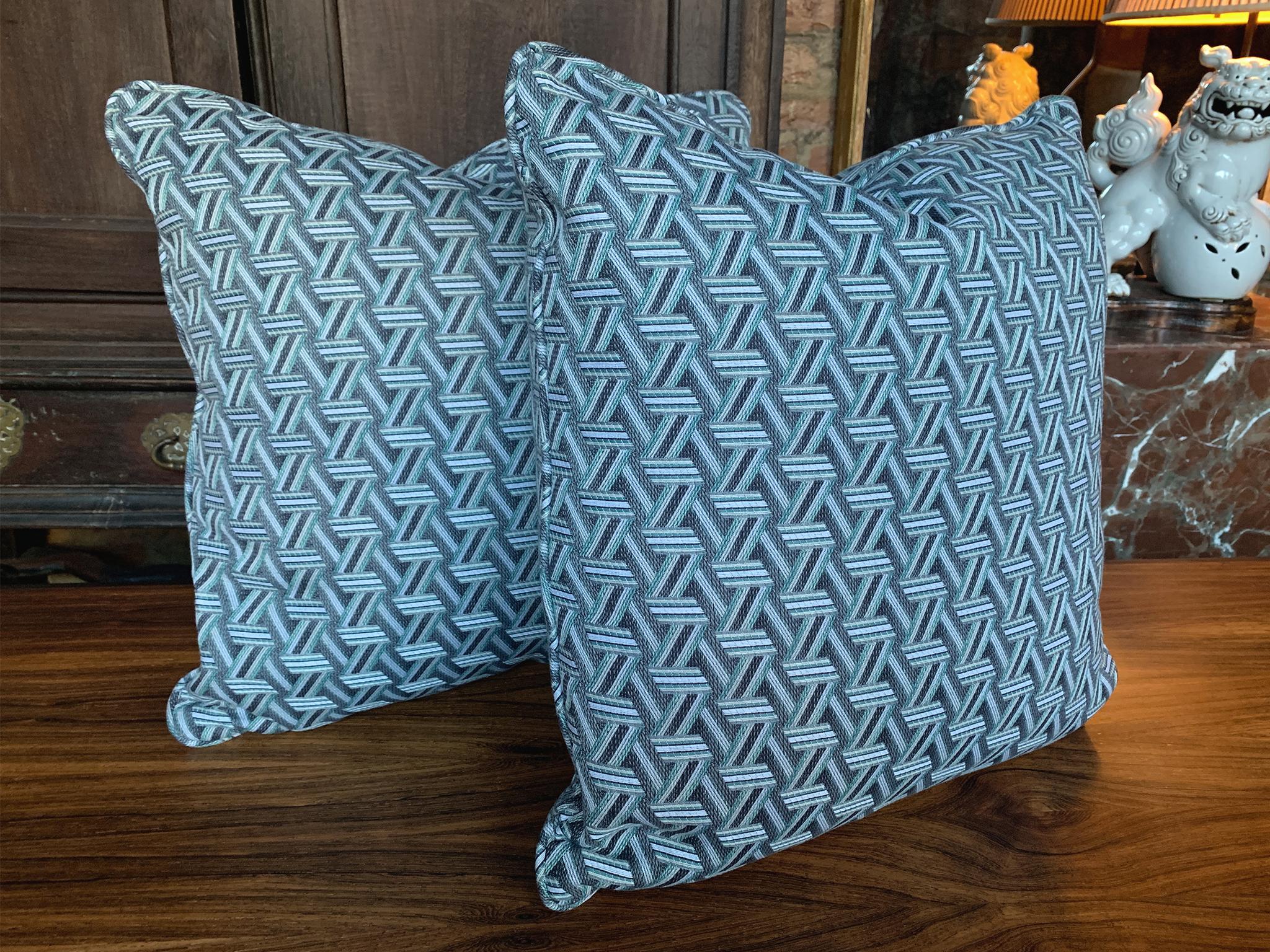 Una coppia di nuovi cuscini quadrati personalizzati realizzati in esclusiva per Cafiero Select. Il tessuto Jewell è una trama Jacquard di Lelièvre della serie TRIBU. Il motivo è un'intricata rete di nastri che si ispira alla lavorazione dei cesti.