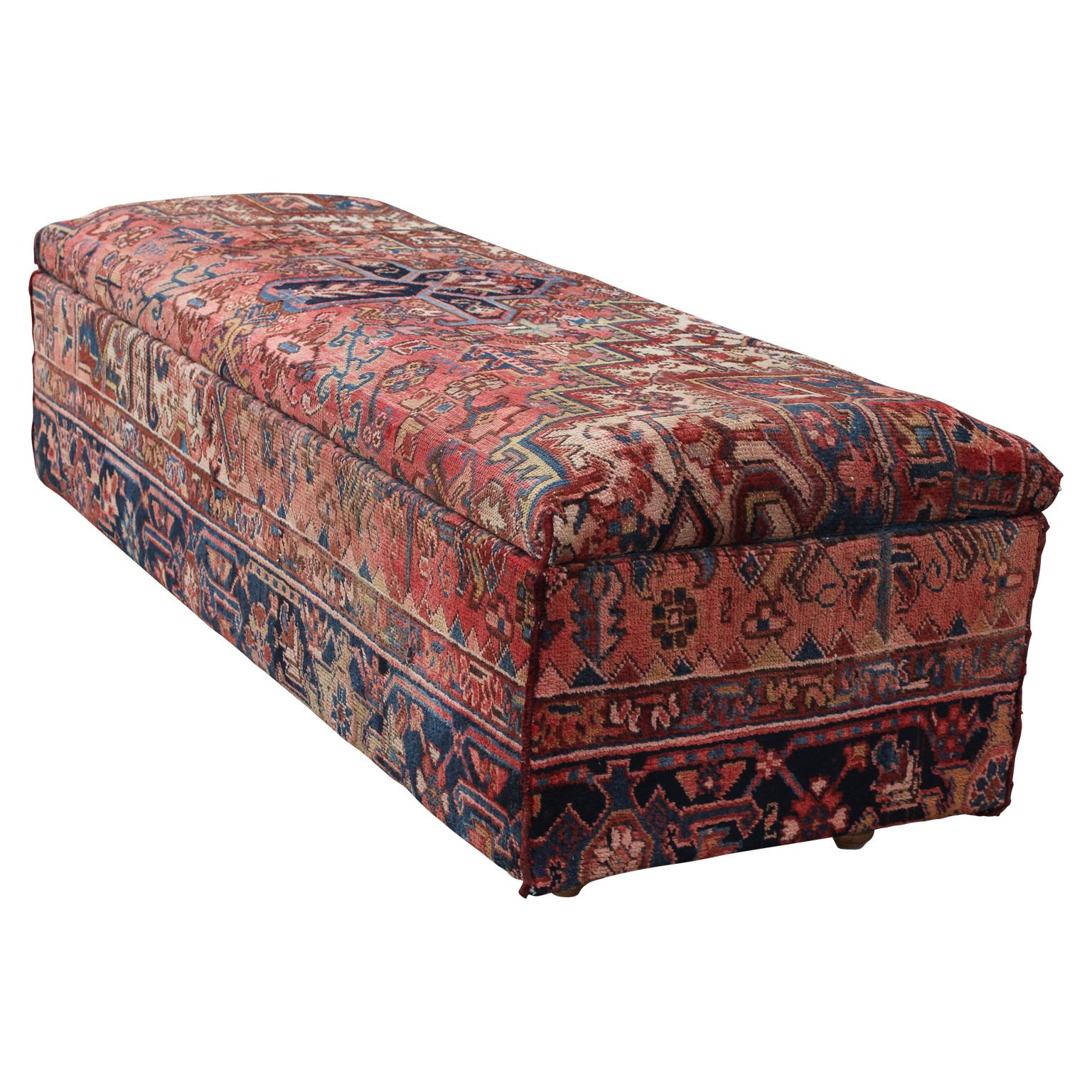 Custom made storage bench upholstered using two different Persian fabrics similar to the Persian Bakshaish rugs. The outside of the bench is a red decorative print and the inside is blue fabric. The piece has wooden feet and sits low to the floor.