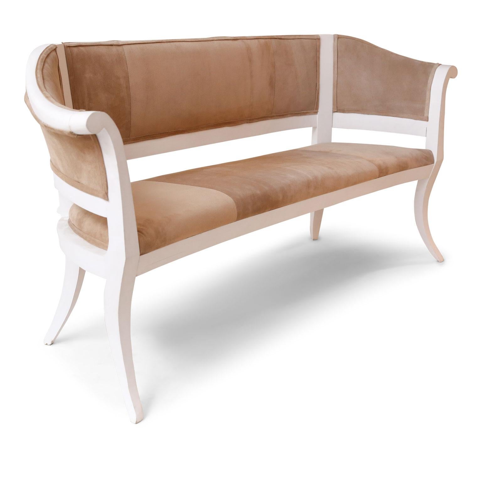 Custom suede upholstered settee, or bench: white painted frame newly-carved in a neoclassical style, backed in linen and upholstered in beige-tan suede. (Seat measures: 20.25 inches high by 65 inches wide by 19 inches deep. Arms are about 32.75