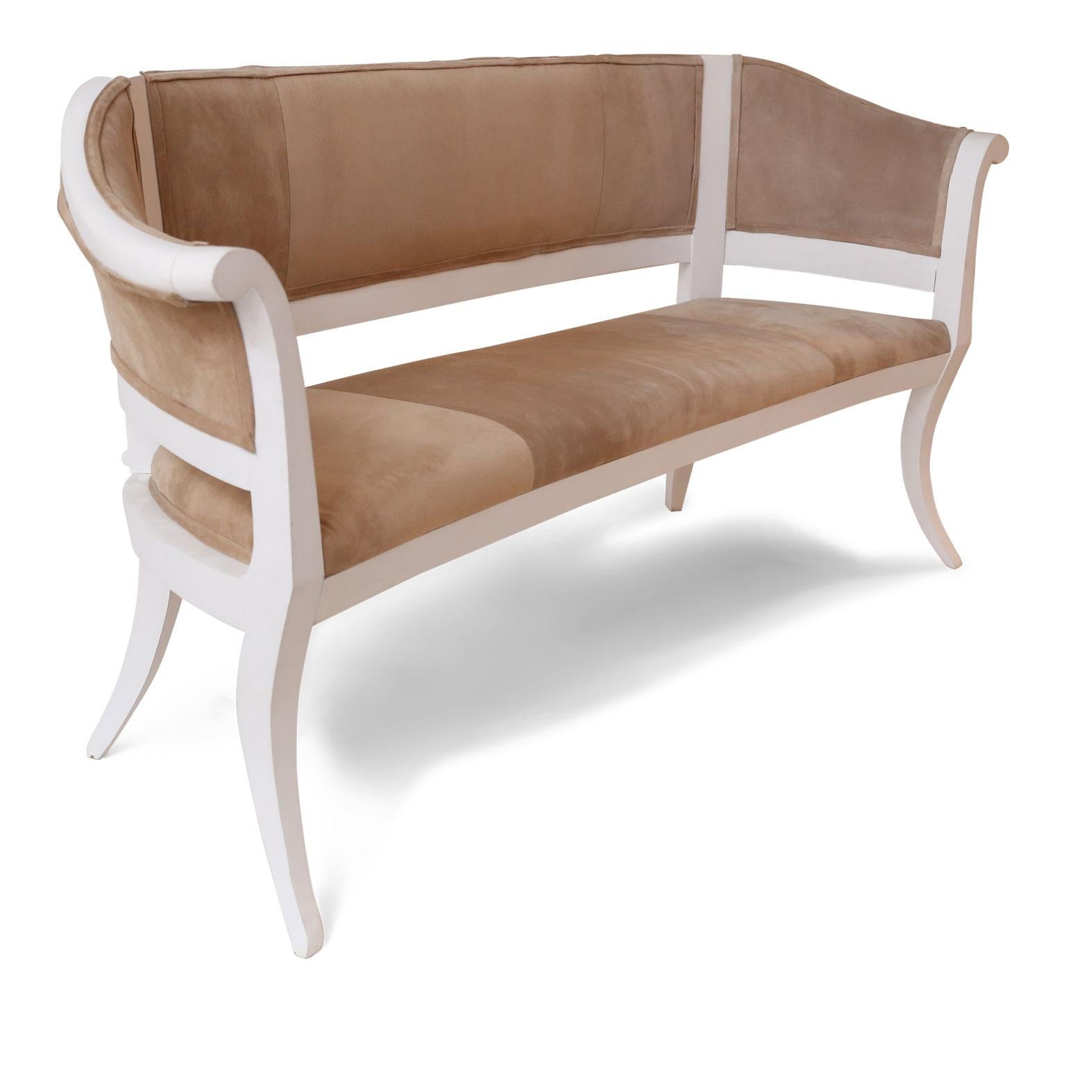Custom suede upholstered settees – a one-of-a-kind pair. Painted frames newly-carved in a neoclassical style and painted in white. Back in linen. (Seat measures 20.25 inches high by 65 inches wide by 19 inches deep. Arms are about 32.75 inches high