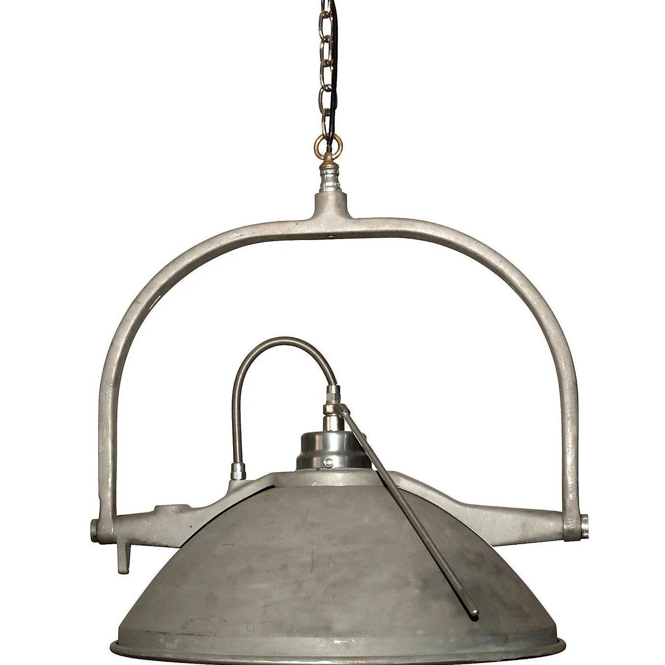 Large hanging lamp that has been repurposed from vintage medical exam lights. They have an adjustable tilt and a mirrored bowl pendant. Suspend a single light over a small dining space or in a gentleman's study. A stunning (and bright) conversation