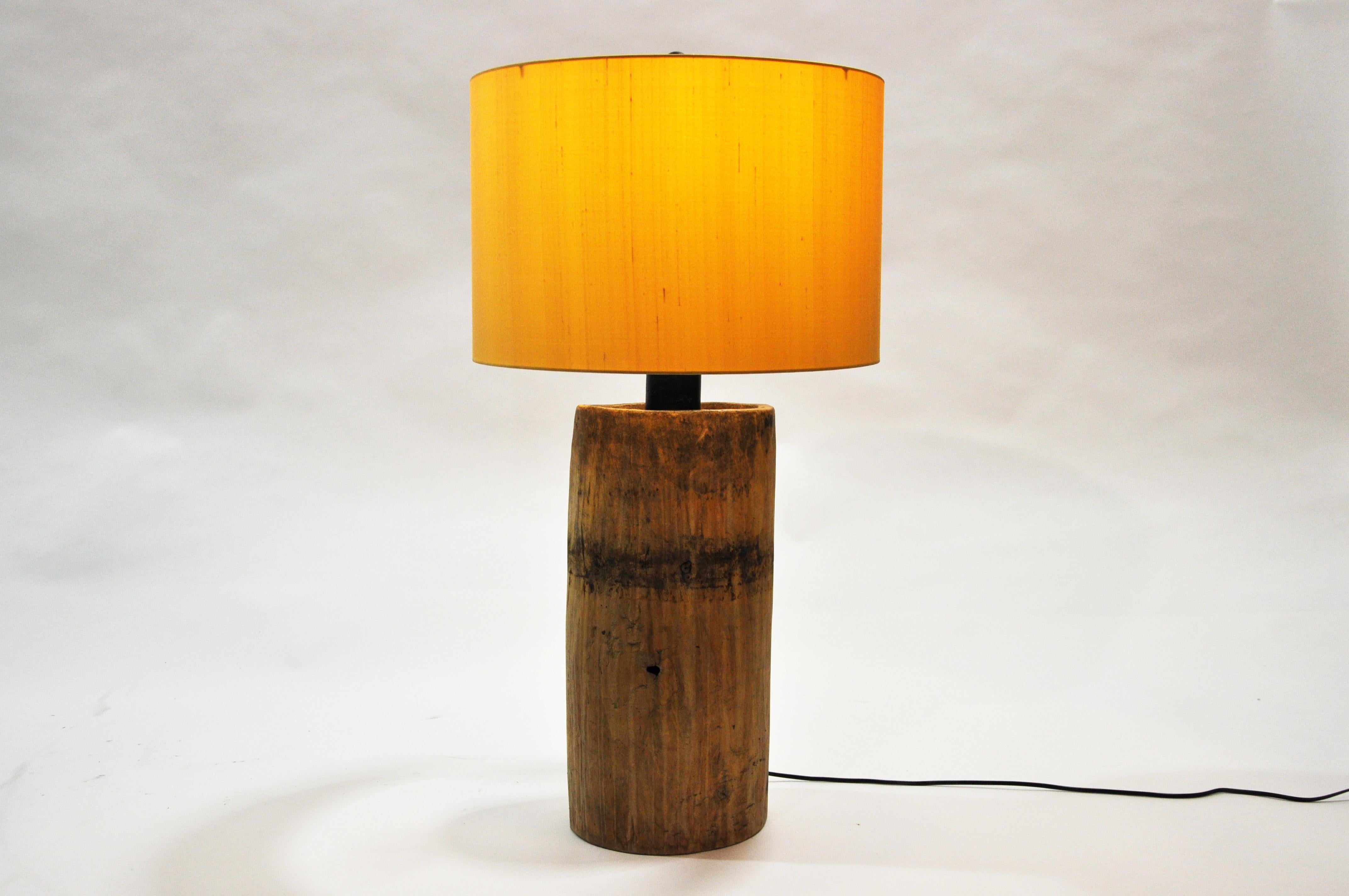 A custom table lamp from Thailand made from a vintage teak wood cylinder.  The cylinder was originally used to hold grain. Our Chicago workshop made the conversion, adding custom wiring and other parts.  The piece is rustic but has an interesting