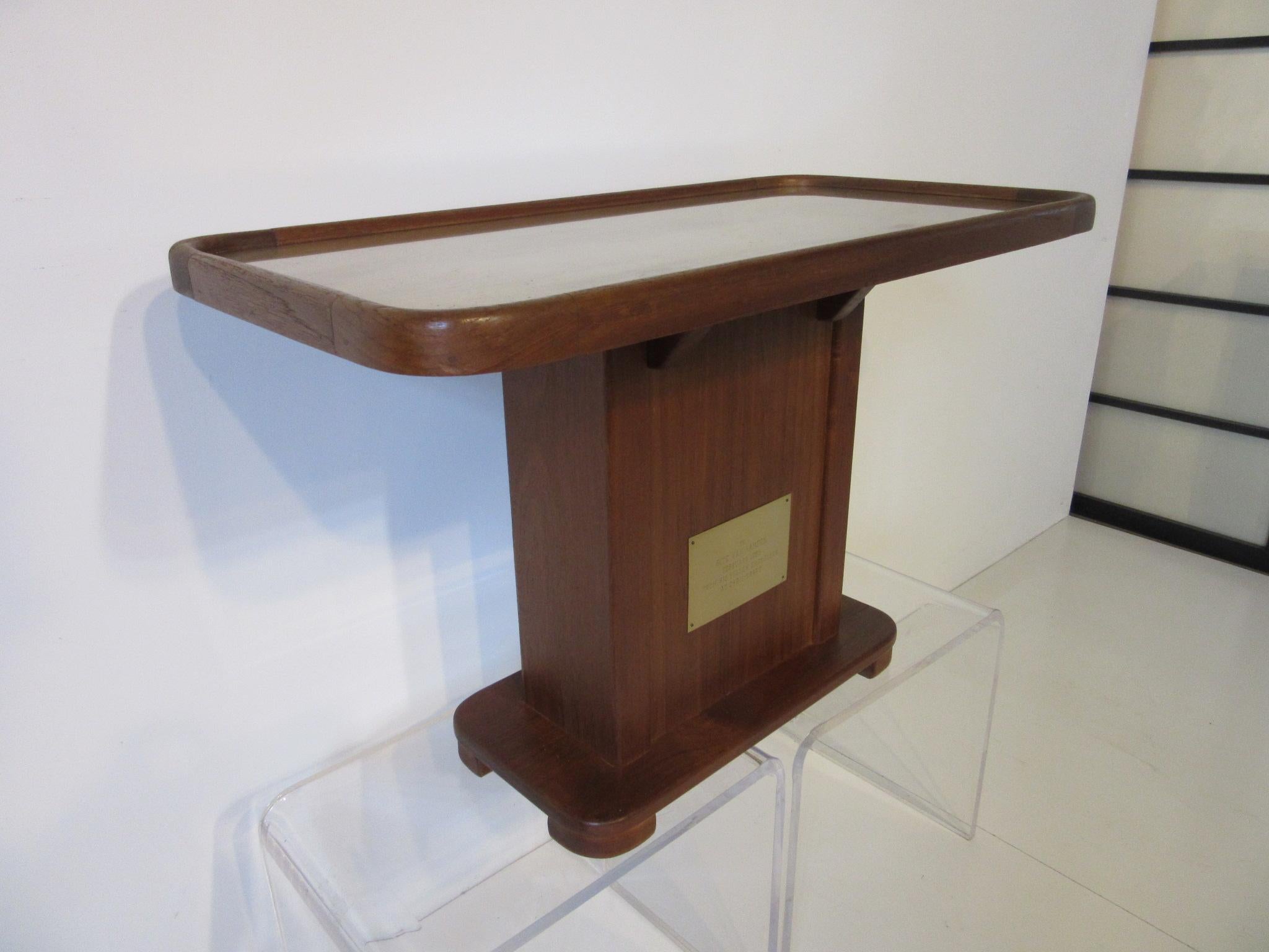 A custom well crafted teak wood side table with brass engraved plaque 