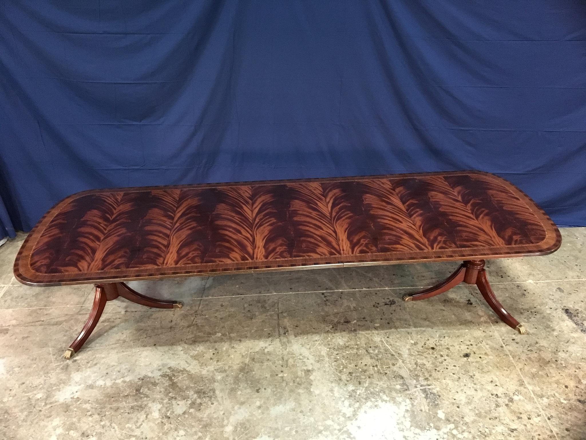This is a made-to-order large traditional mahogany dining table made by Leighton Hall. It features a field of slip-matched swirly crotch mahogany from West Africa and straight grain mahogany and Santos rosewood borders from South America. The