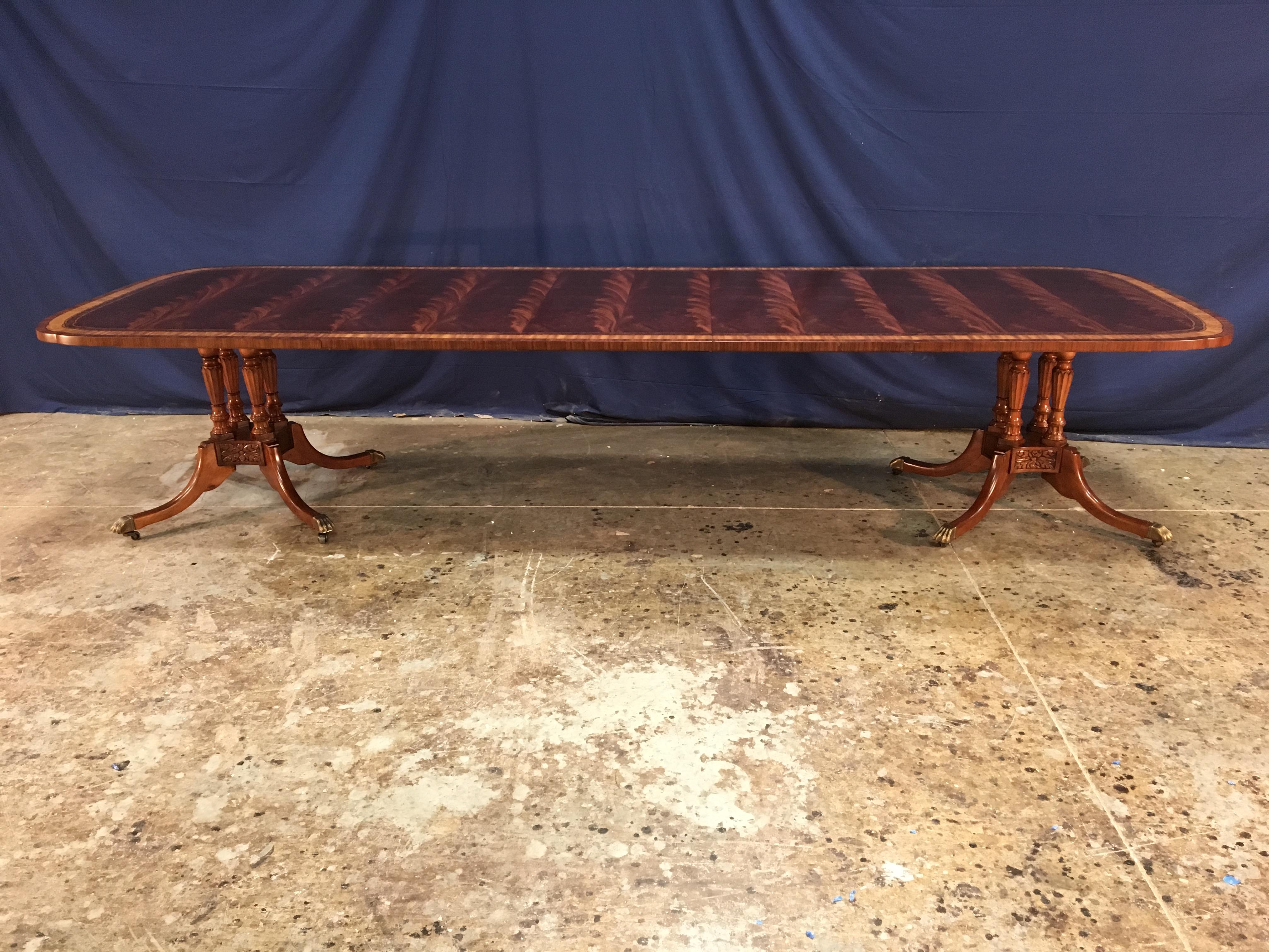 This is a made-to-order traditional mahogany dining table made by Leighton Hall. It’s double scalloped corners gives it a unique delicate shape. It features a field of slip-matched swirly crotch mahogany from West Africa and satinwood, burled walnut