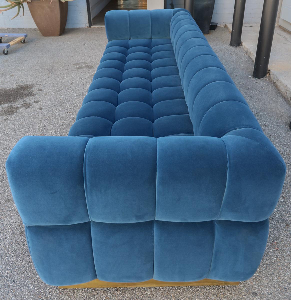 Custom tufted sofa with handmade brass base in blue velvet.  Made in Los Angeles by Adesso Imports. Can be made in different sizes, colors and fabrics or a different metal for the base.