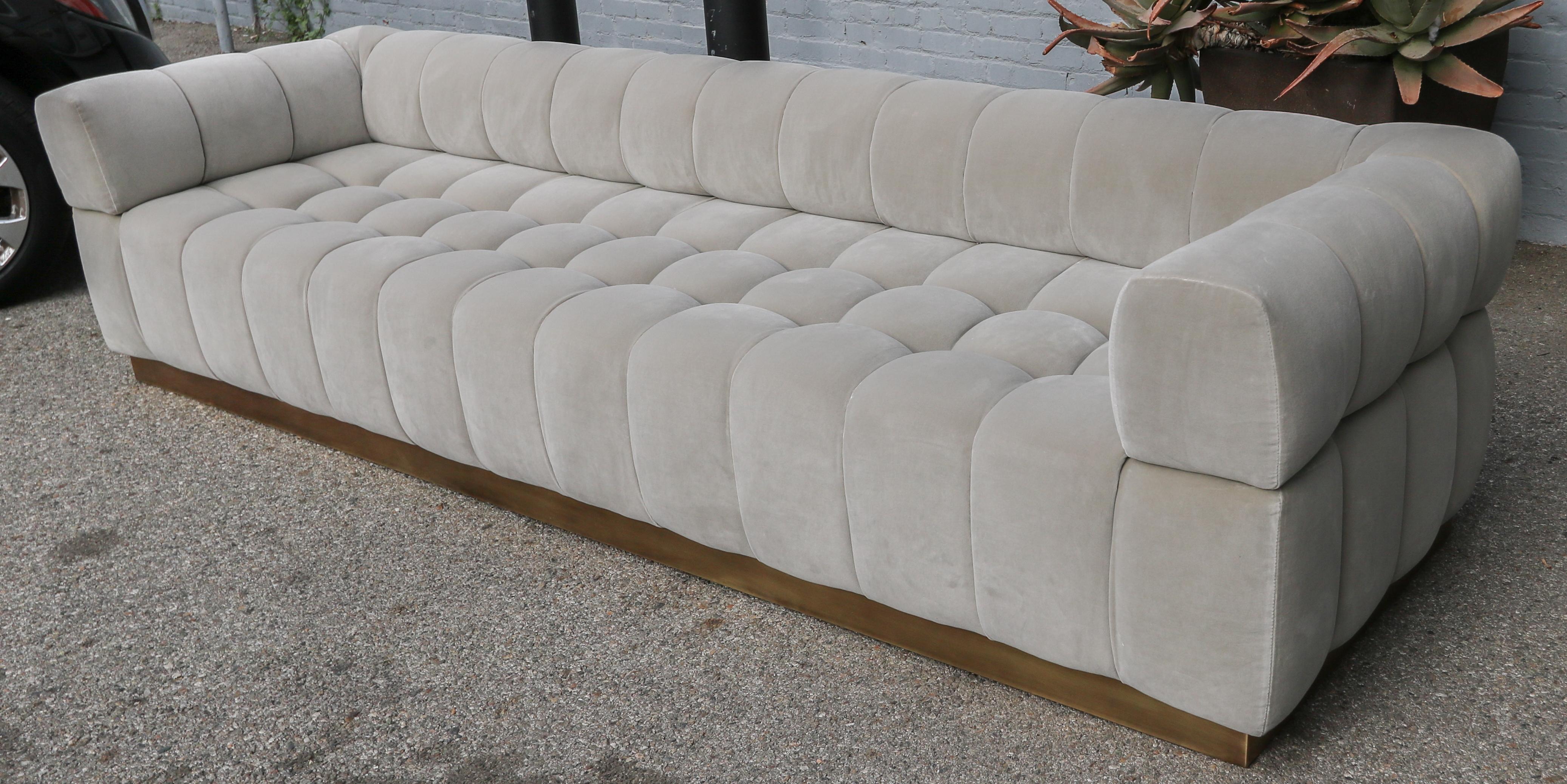 Custom tufted sofa with handmade brass base in grey velvet.  Made in Los Angeles by Adesso Imports. Can be made in different sizes, colors and fabrics or a different metal for the base.