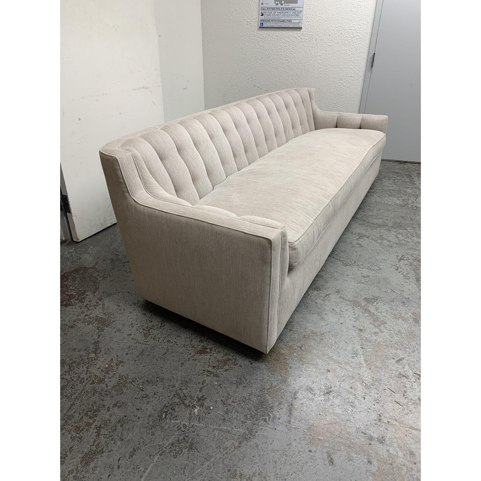 Presents a custom tufted shell slope arm sofa. Tufted and channeled upholstery line the low sculptural back. Firm back fabrication is nicely balanced with down filled bench seat. Bench seat is cut to fit the channeled upholstery on back. Fabric is a