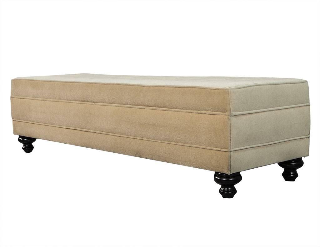 This modern bench is as functional as it is beautiful. If desired, the piece can double as a chaise longue. Cloaked in custom upholstery, so you can easily find your perfect match. The fabric pictured is a nice, neutral light brown, sitting atop