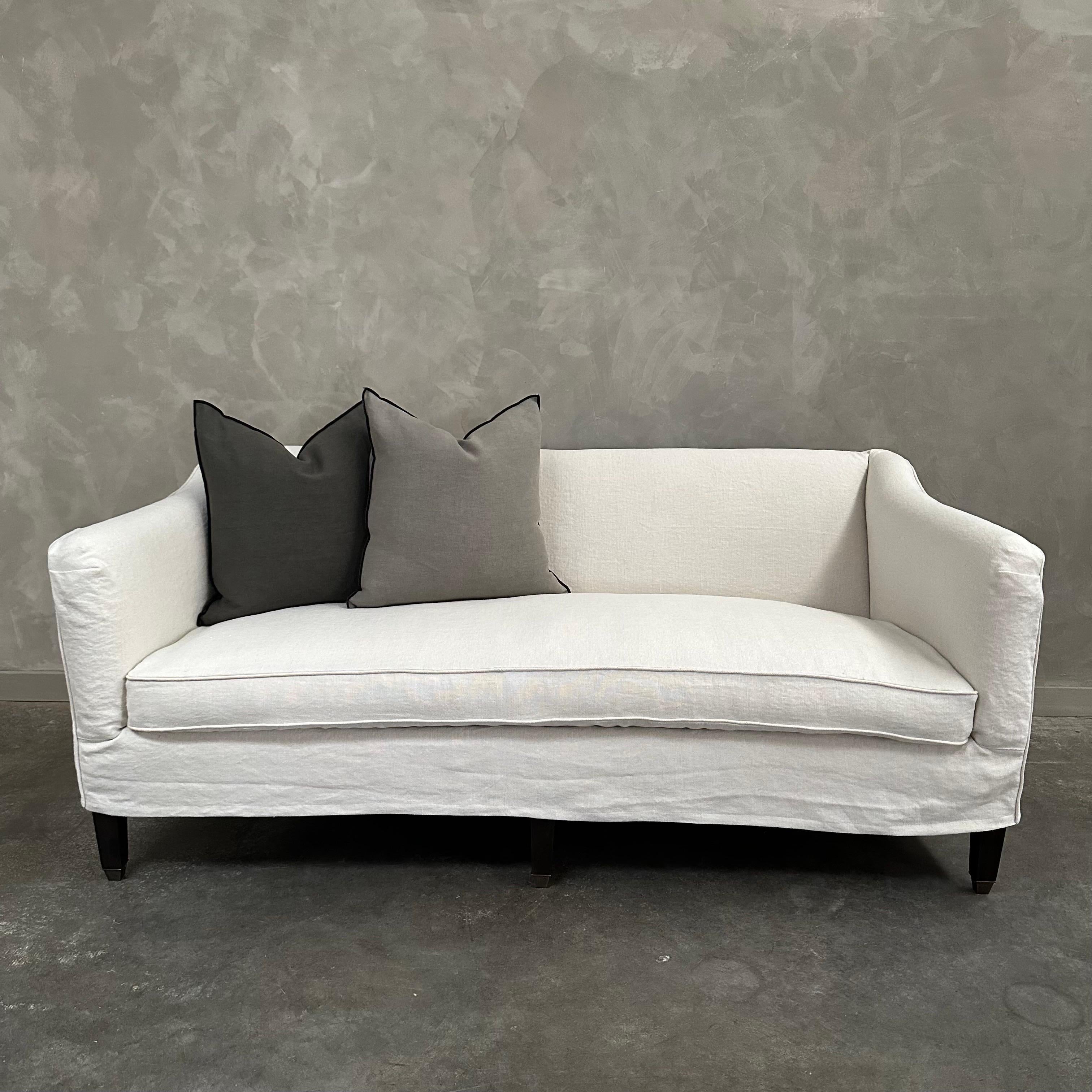Bloom Slip Covered Sofa / or Upholstered
Shown: Slip covered in a heavy stone washed Belgian linen in Semi-Bleached Oatmeal 
Legs: Dark Walnut Finish with Brass Finished Caps
Single bench seat cushion in medium density foam with a down / feather
