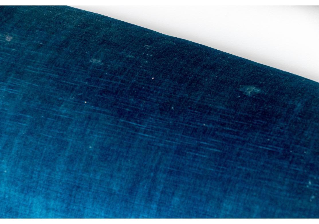 Un spectaculaire et coloré canapé de style Hollywood Regency tapissé de bleu avec des accoudoirs roulés, des coussins d'assise molletonnés, des garnitures tournées en corde et une base frangée. 

Dimensions : 87