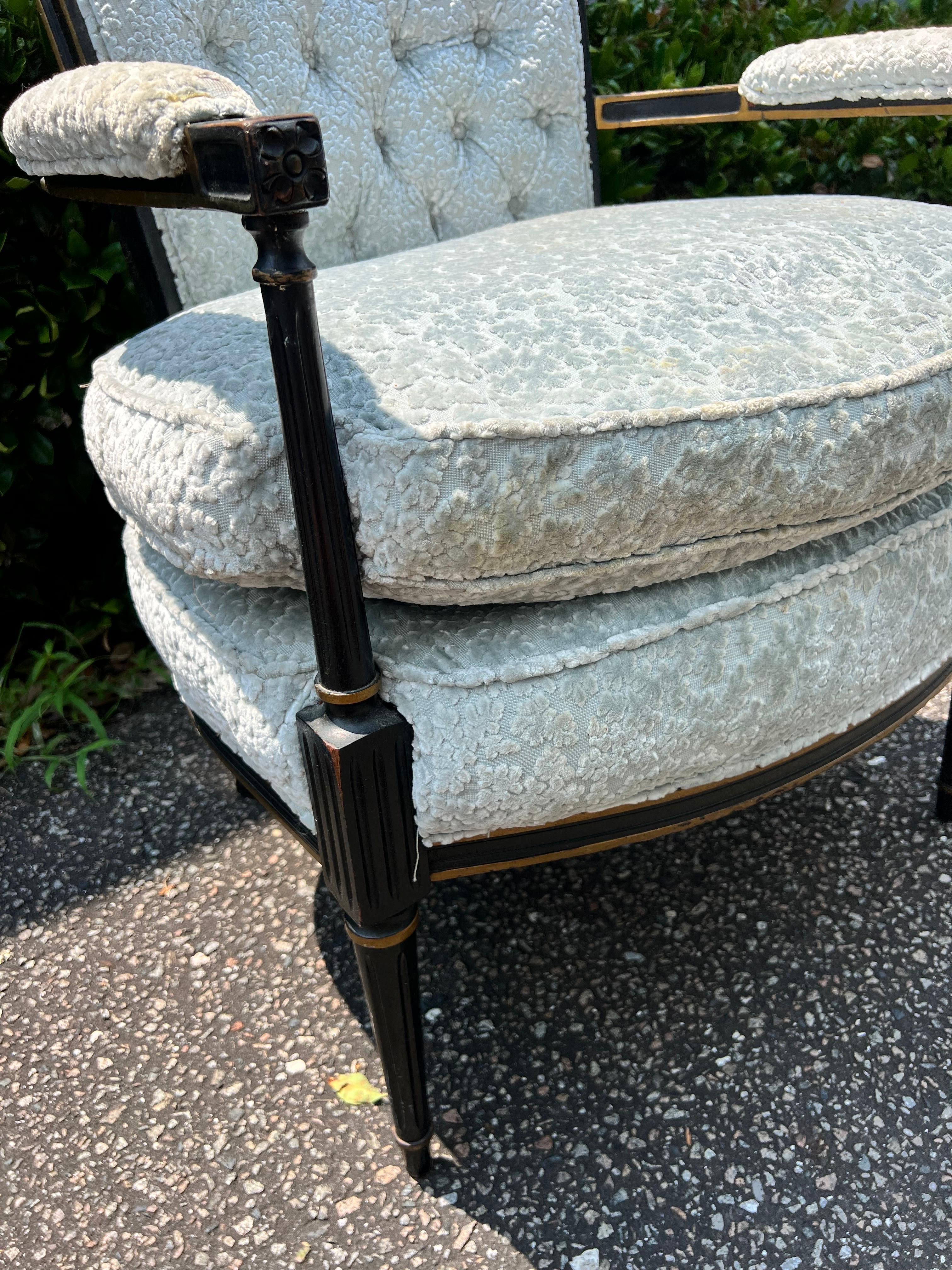 A  vintage Louis XVI-style ebonized giltwood bergere armchair, with a square button-tufted back, and a comfortable large cushion base. DIMENSIONS
26ʺW × 21ʺD × 34.5ʺH.   Previously upholstered in a designer raised flower velvet upholstery fabric. 