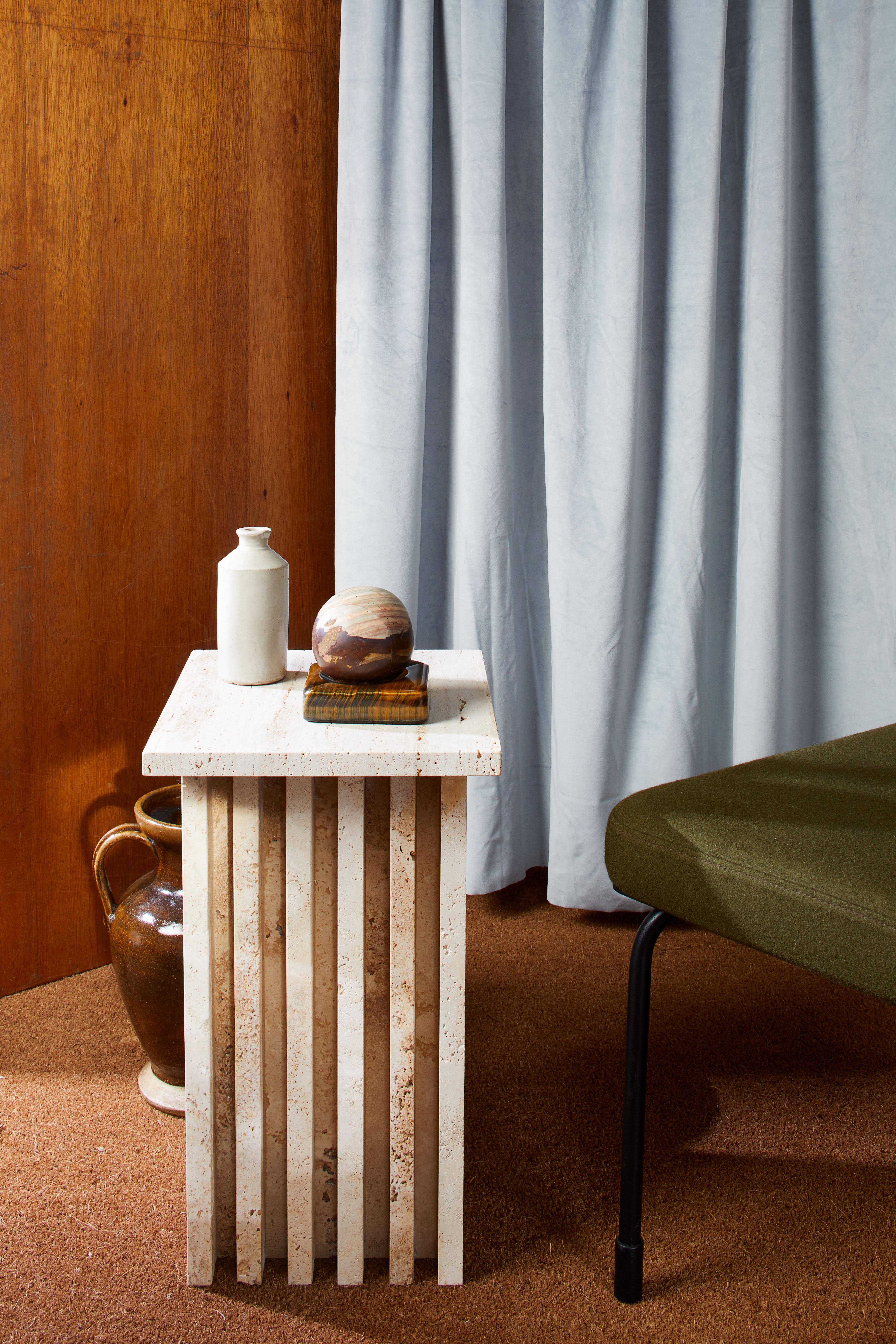 Designed as a midpoint between a sculpture and an accessory, the Vondel side table in unfilled Travertine presents a sense of permanence – giving it a strong presence in a space. Structural integrity and strong lines offer a timeless silhouette,